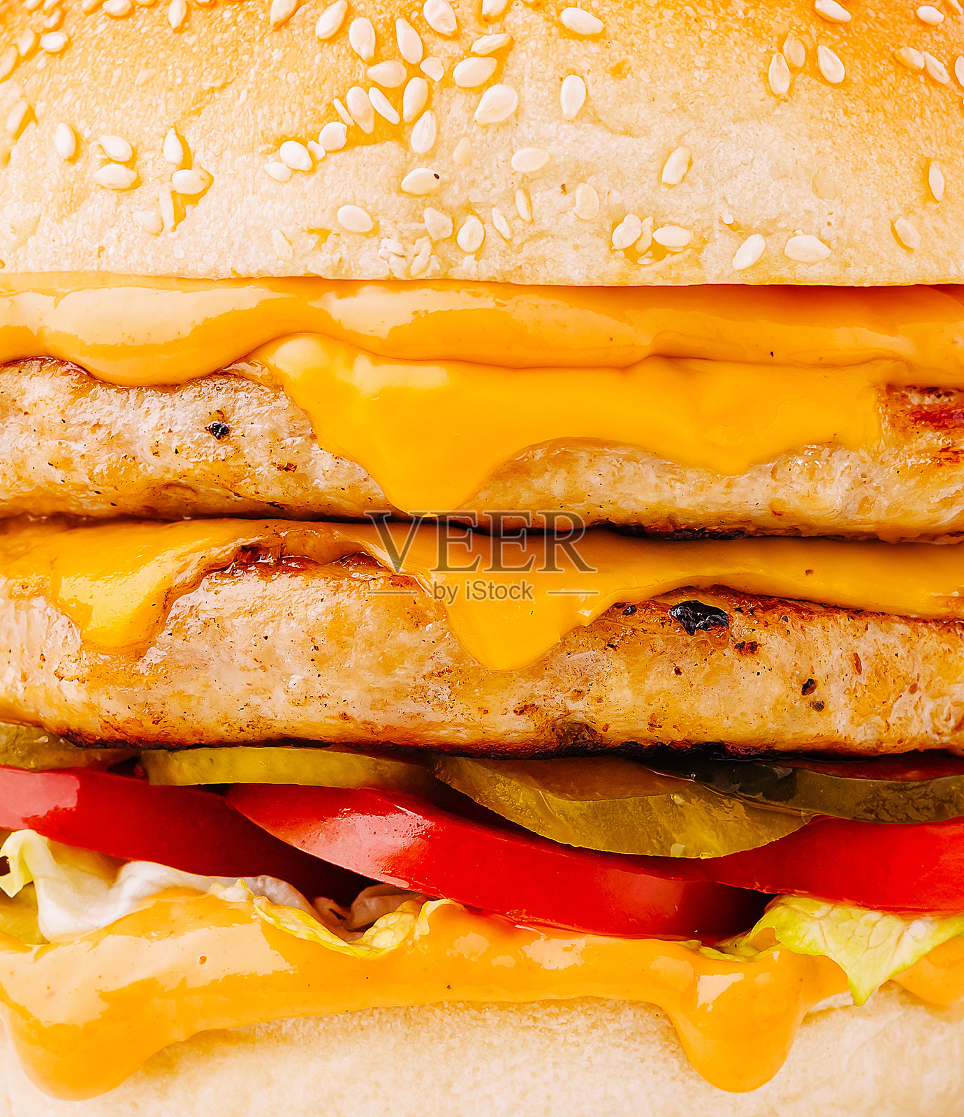 多汁的双层芝士汉堡，配有融化的奶酪和新鲜的配料照片摄影图片