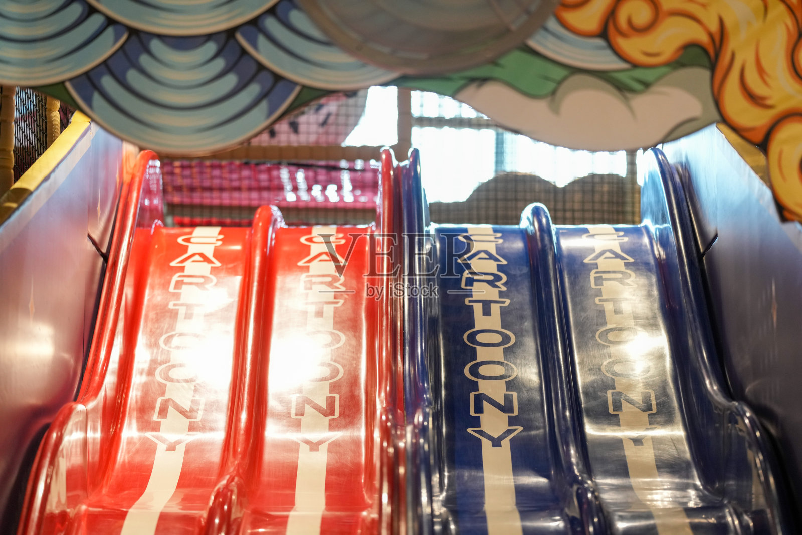 五彩斑斓的球池中，一条滑梯在明亮的圆球间升起，柔和的光线在其表面闪烁，空间里充满了欢快的回声。中国上海市虹口区。2025年6月2日。春季。照片摄影图片