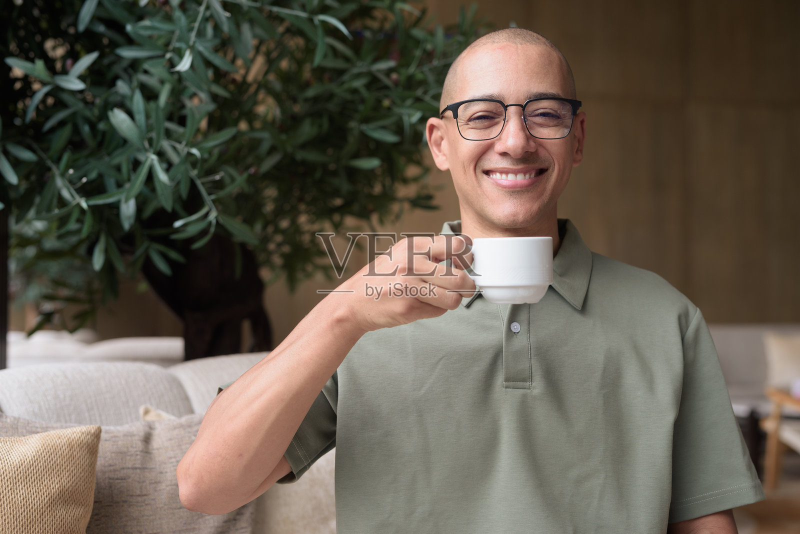 西班牙裔男子在酒店酒吧休息区手持咖啡杯，体现了热情好客、放松和休闲优雅。照片摄影图片