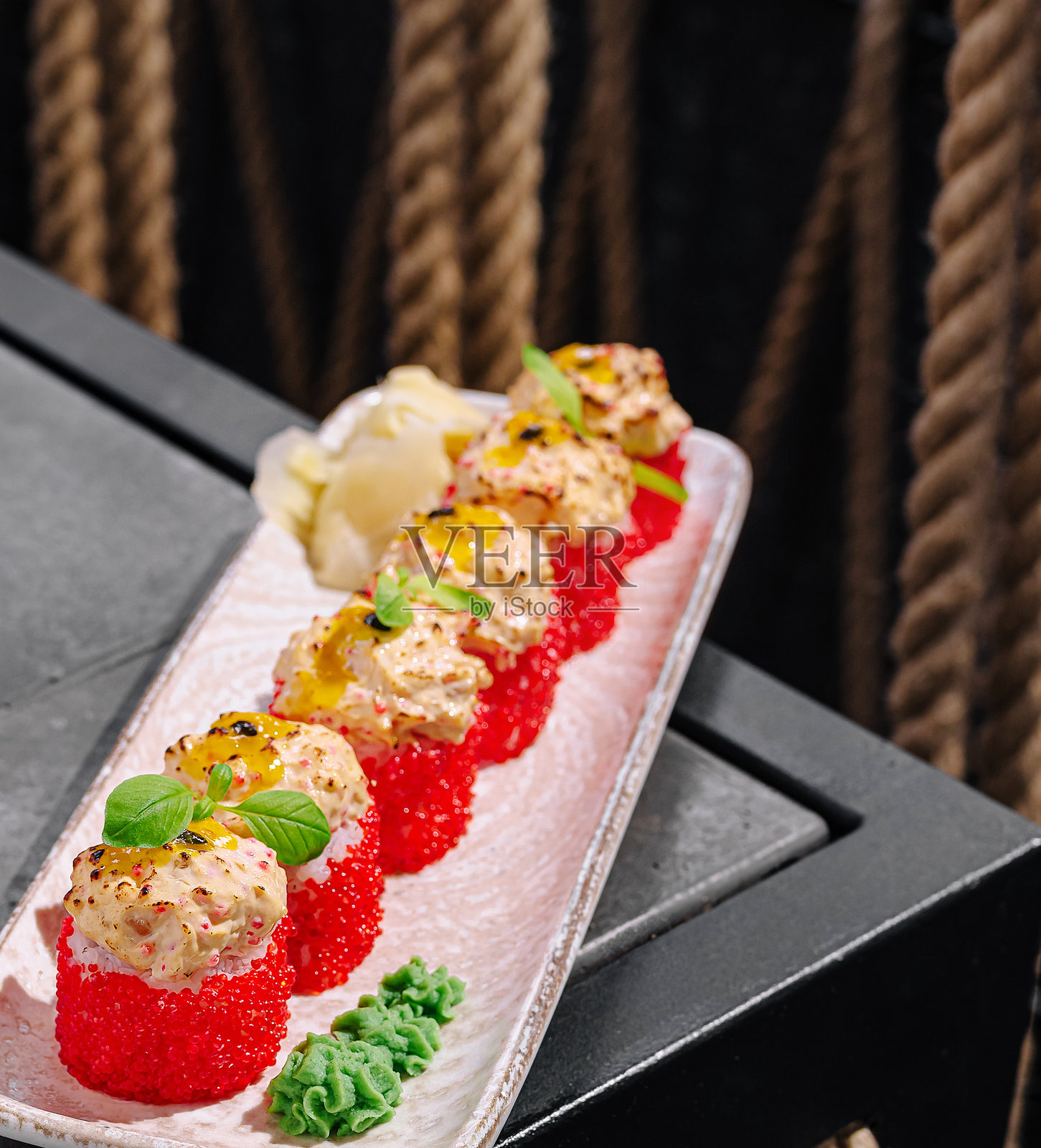 色彩鲜艳的寿司拼盘摆放在现代黑色桌子上照片摄影图片