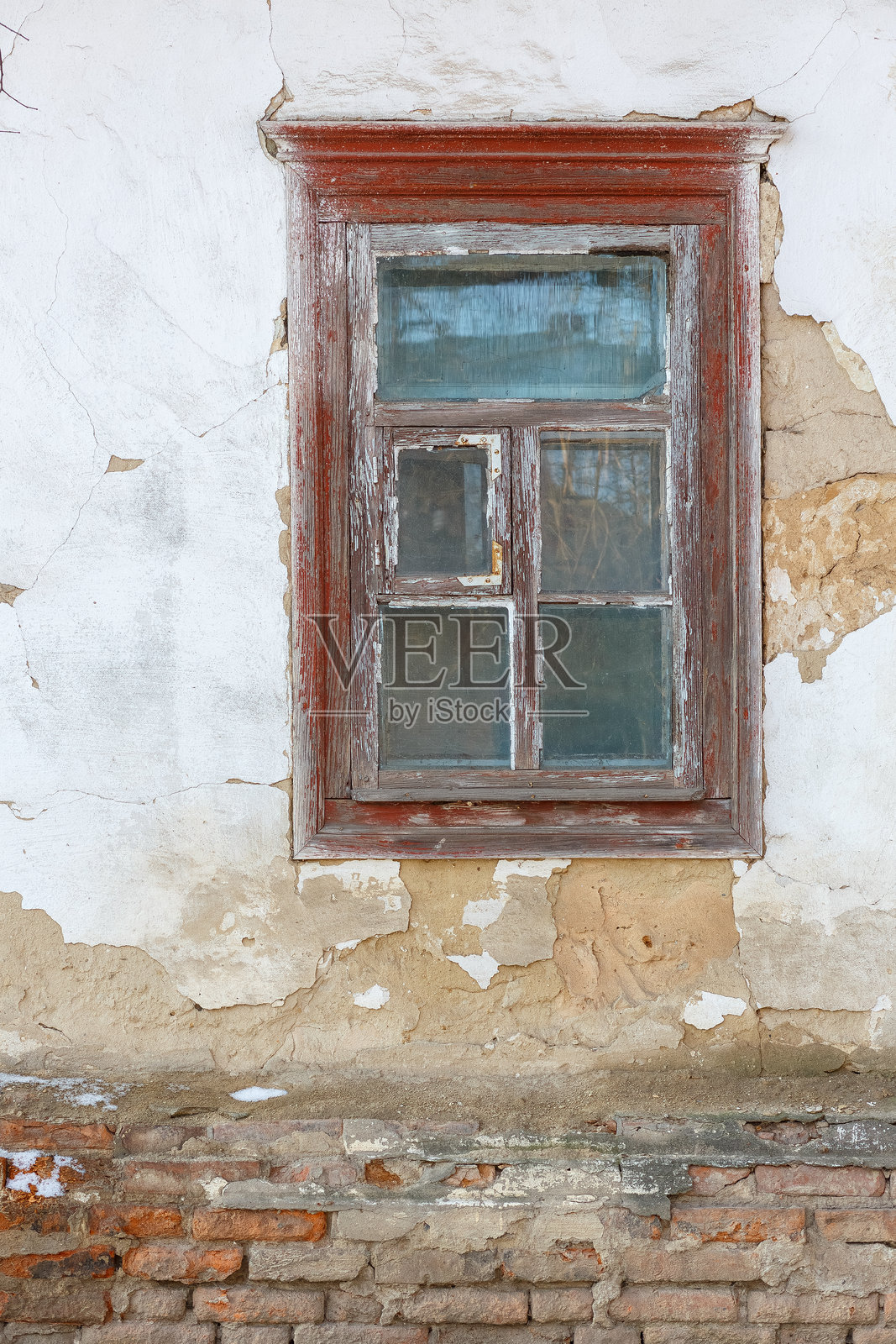 老旧的木窗户嵌在风化的砖墙上照片摄影图片