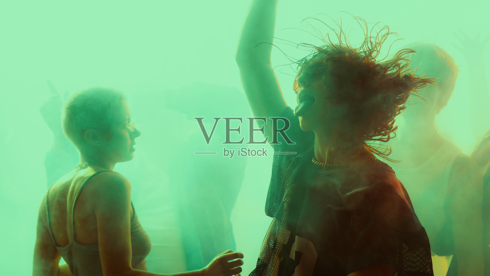 在充满活力和色彩斑斓的派对氛围中，剪影人物在跳舞。照片摄影图片