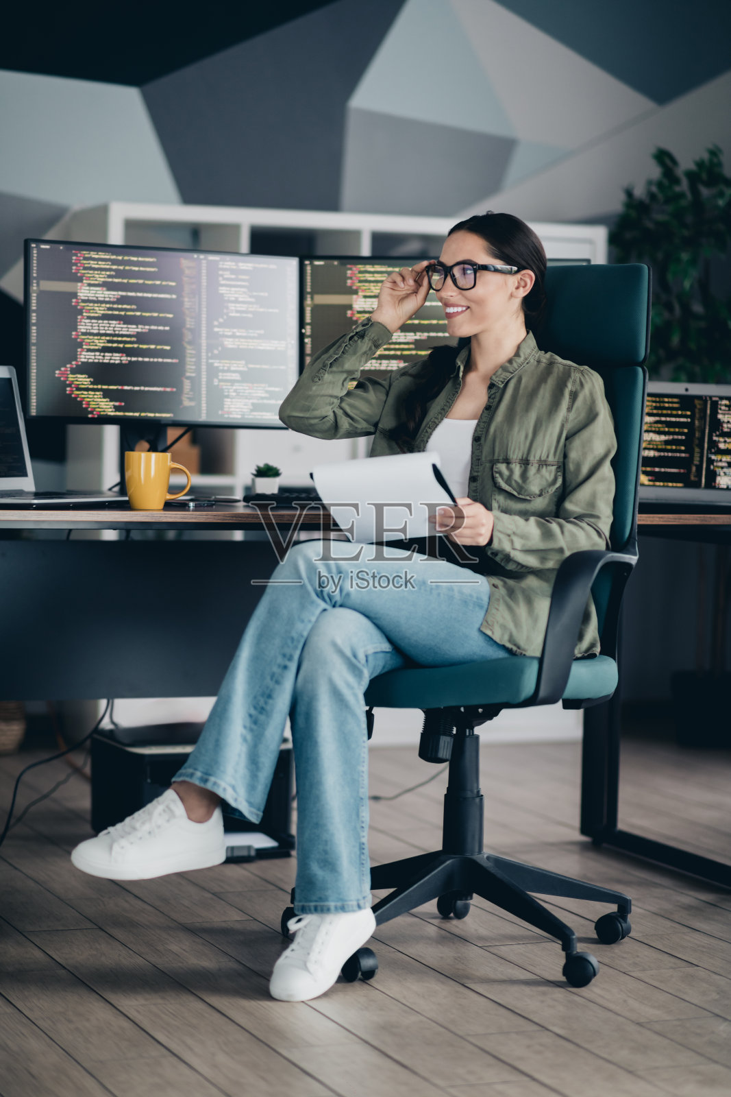 迷人的女性IT专家在现代办公室环境中自信地微笑着编程照片摄影图片