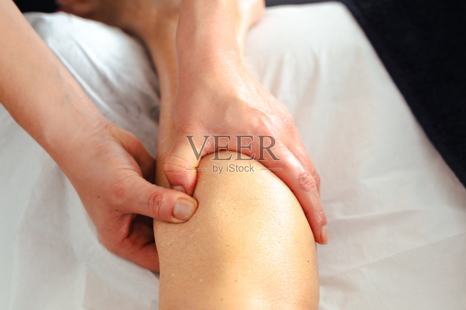 治疗师在水疗过程中为客户按摩腿部的特写镜头照片摄影图片