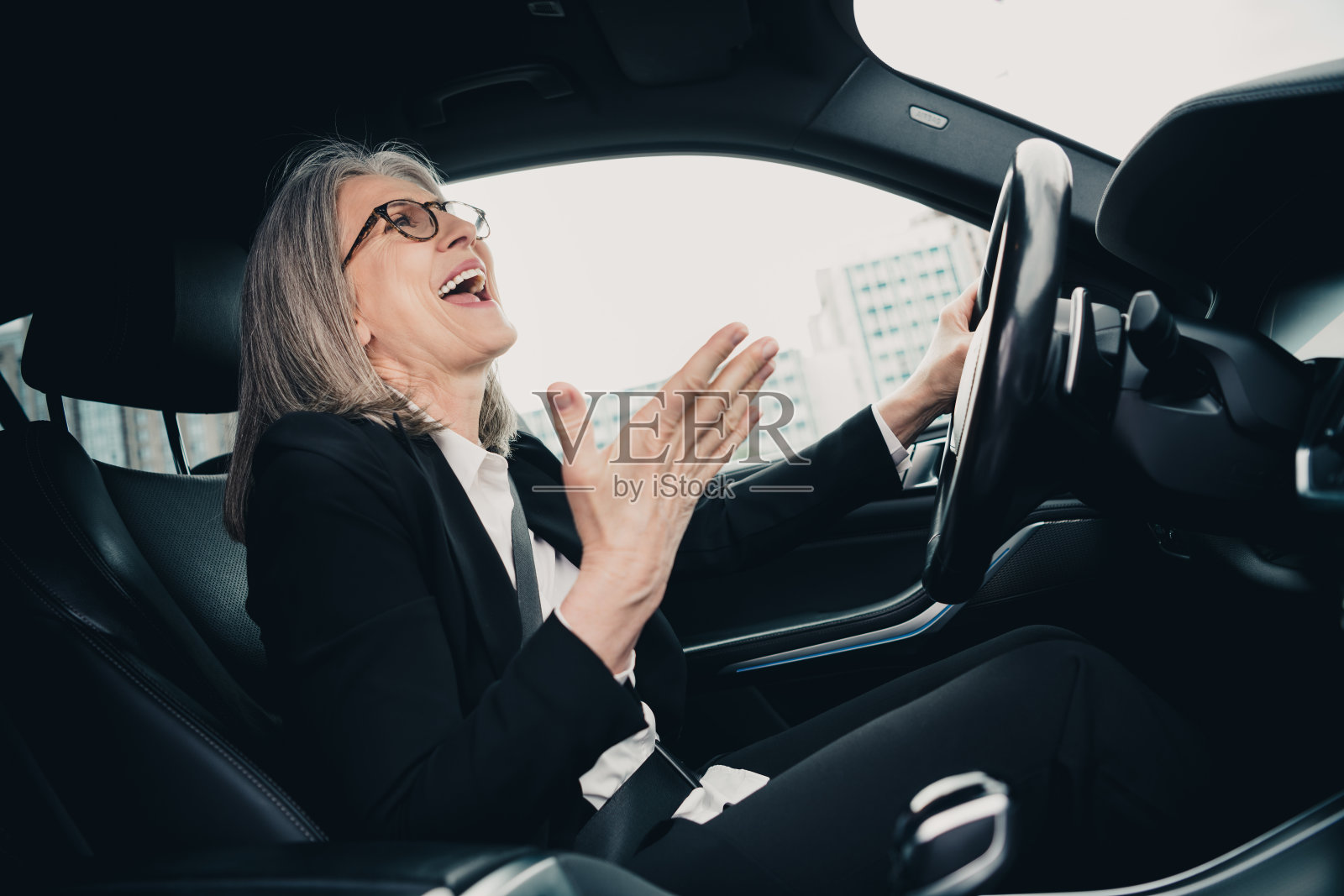 自信的女高管在白天城市中驾驶汽车，展现成功的职业生活方式照片摄影图片