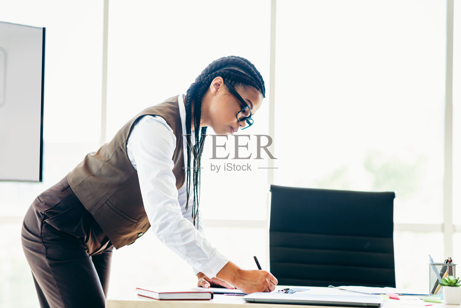 成功的女商人在现代办公室的桌子上专注于工作和商业任务照片摄影图片