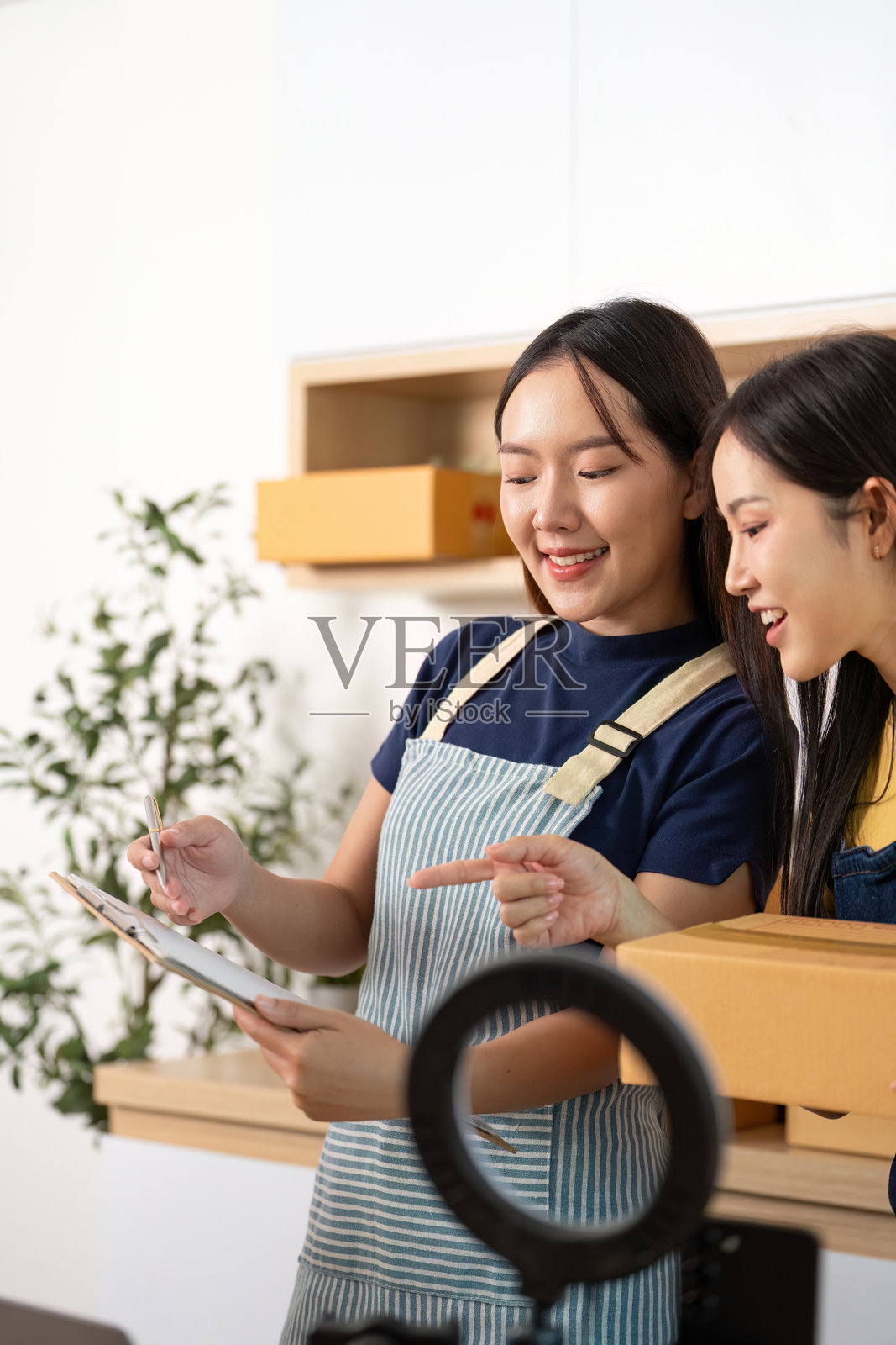 电子商务。两位女性微笑着讨论库存管理。照片摄影图片