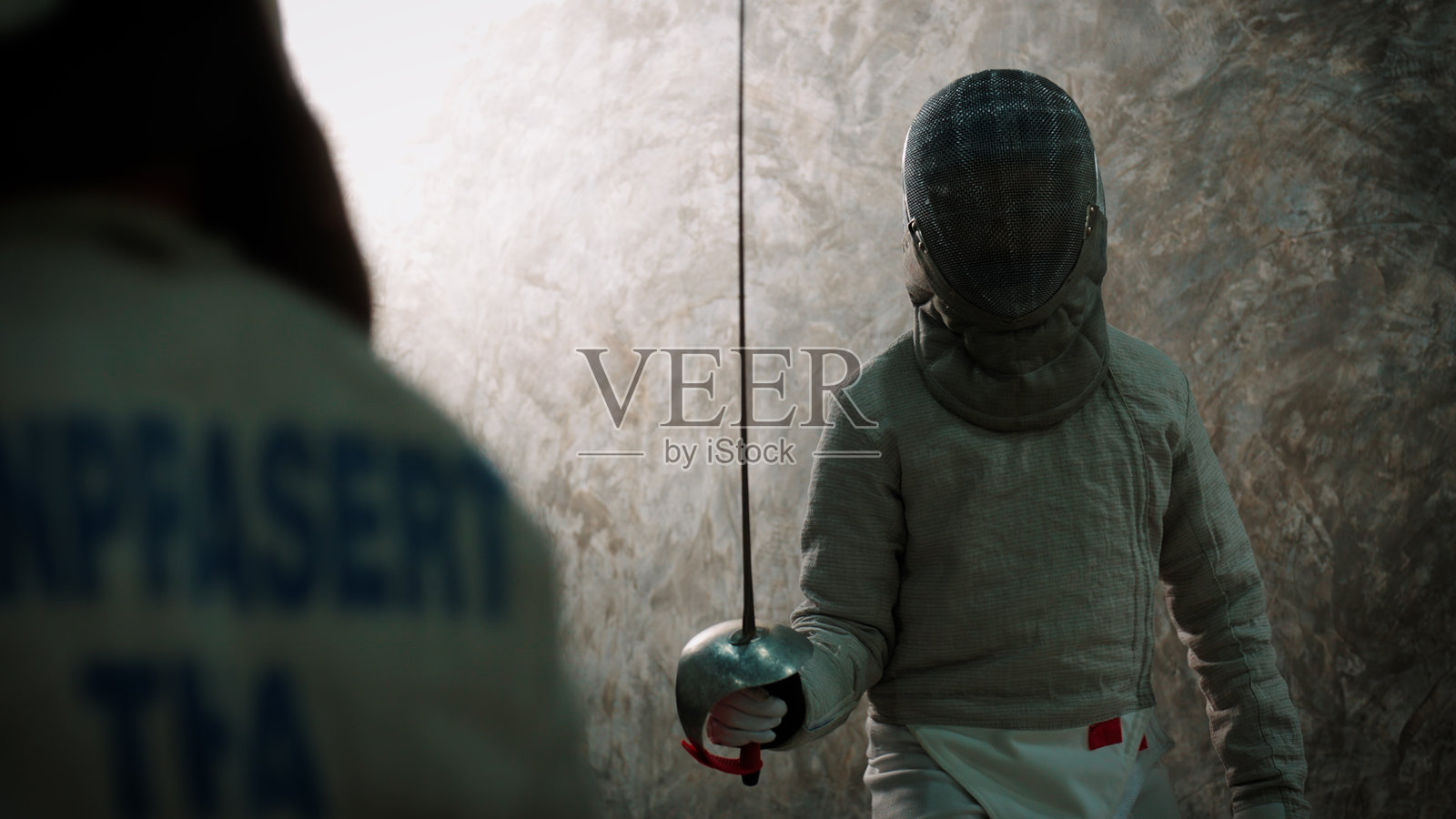 两名年轻的击剑运动员在激烈的对抗赛中较量，测试他们的技能和反应能力照片摄影图片