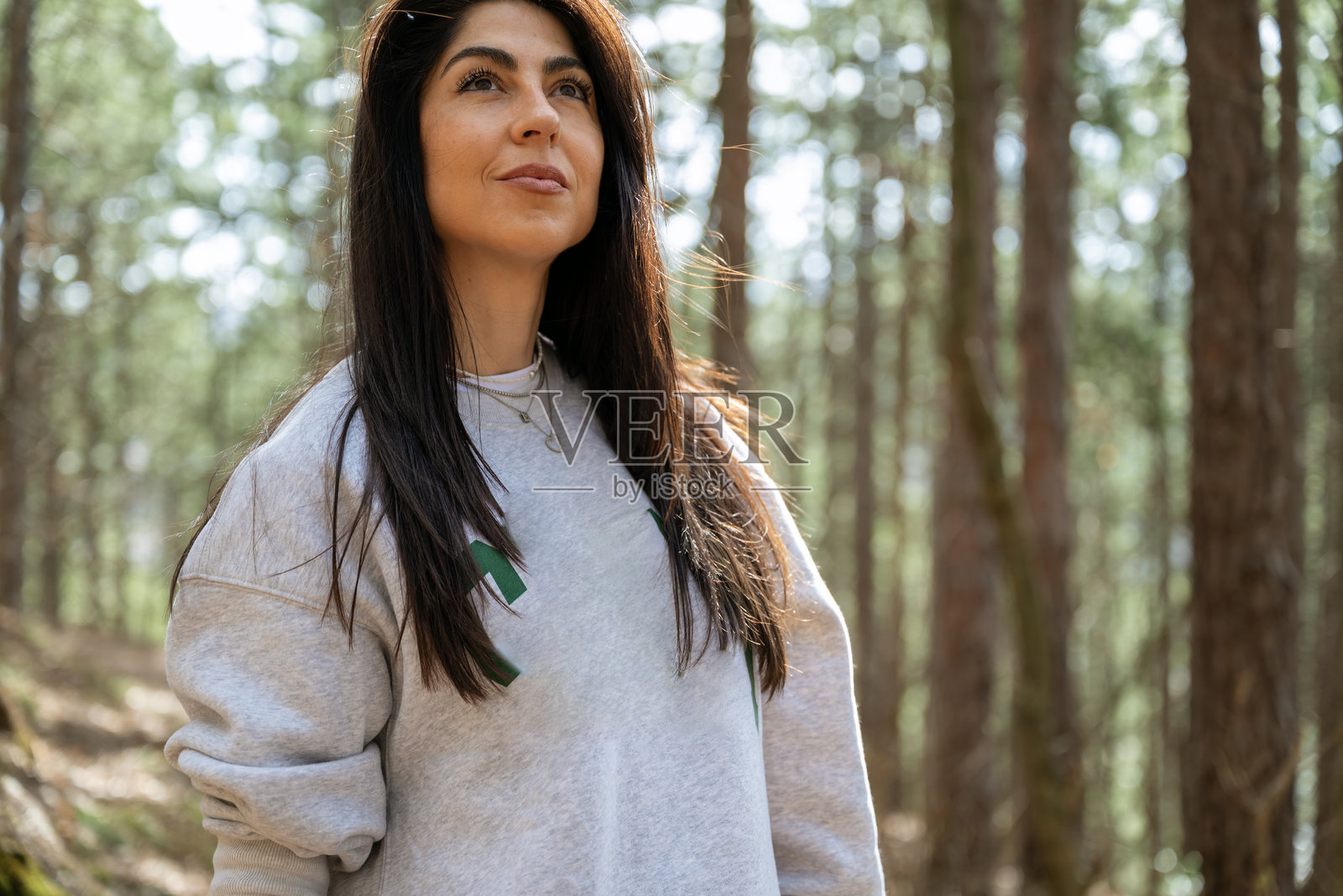 放松的女性在松树林中呼吸新鲜空气照片摄影图片