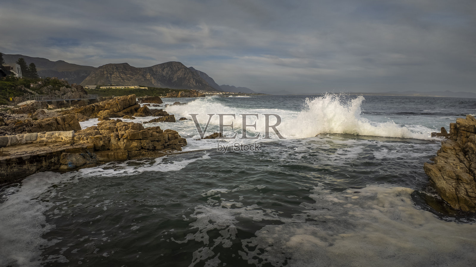 赫曼努斯海岸线的风景如画的悬崖小径全景，俯瞰沃克湾、崎岖的岩石和南非西开普省鲸鱼海岸的山脉。照片摄影图片