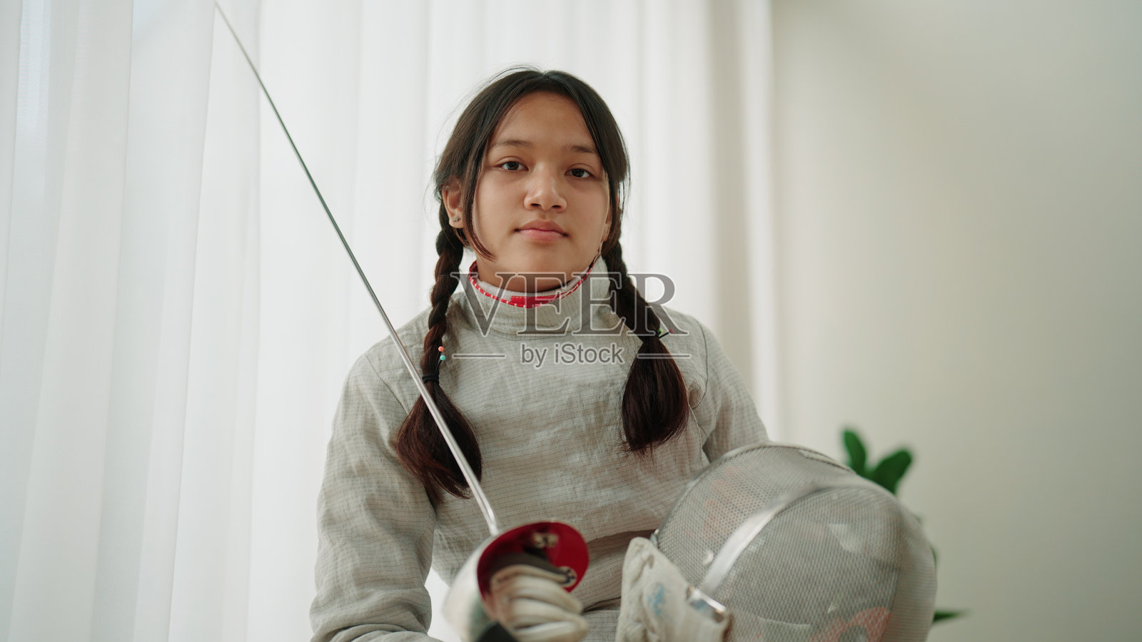 一位年轻女击剑手坚定地直视镜头的肖像照片摄影图片