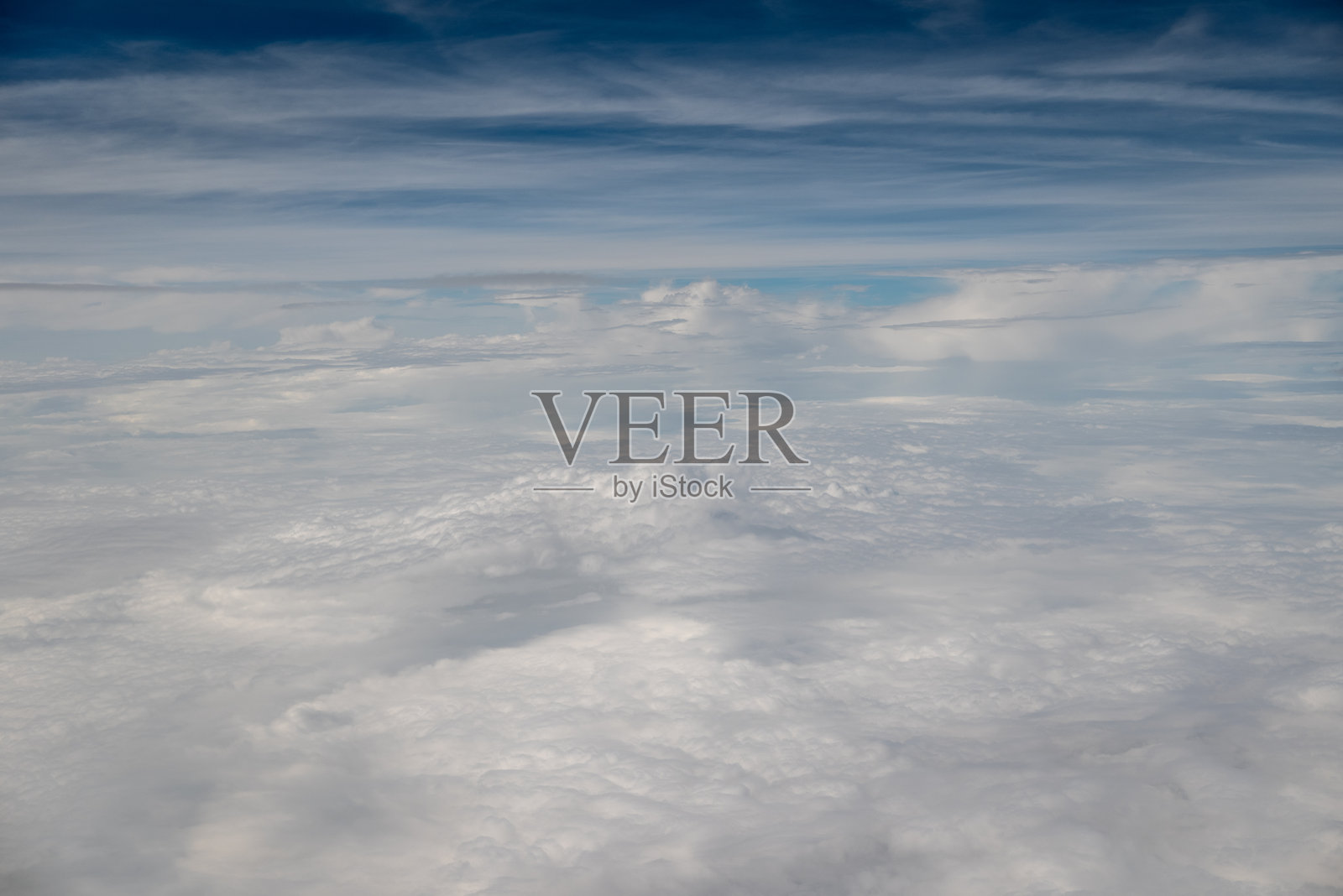 蓝天上飘着轻柔的白云，俯瞰下方的蓬松白云。照片摄影图片