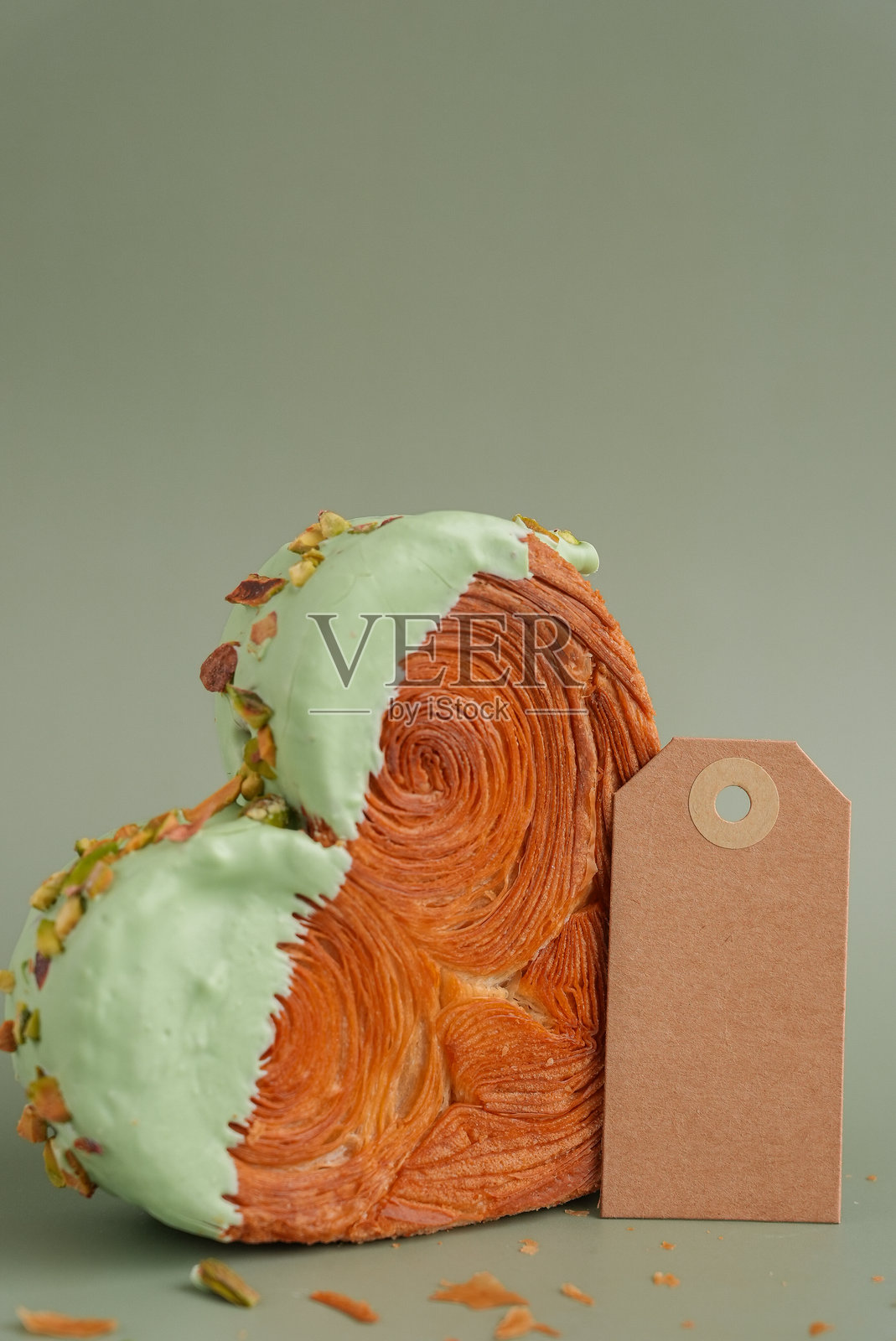 空白纸条模板模拟图 美味新鲜的可颂面包，上面覆盖着抹茶味甘纳许。独特的心形烘焙创作。酥皮点心节日爱情礼物创意，情人节礼物。照片摄影图片