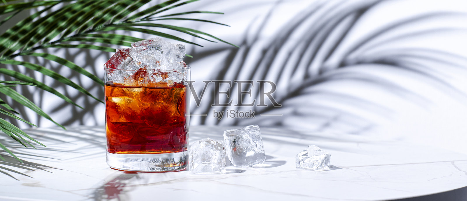 浓烈的红色鸡尾酒，含有苏格兰威士忌、雪利酒、利口酒、苦味酒和冰块照片摄影图片