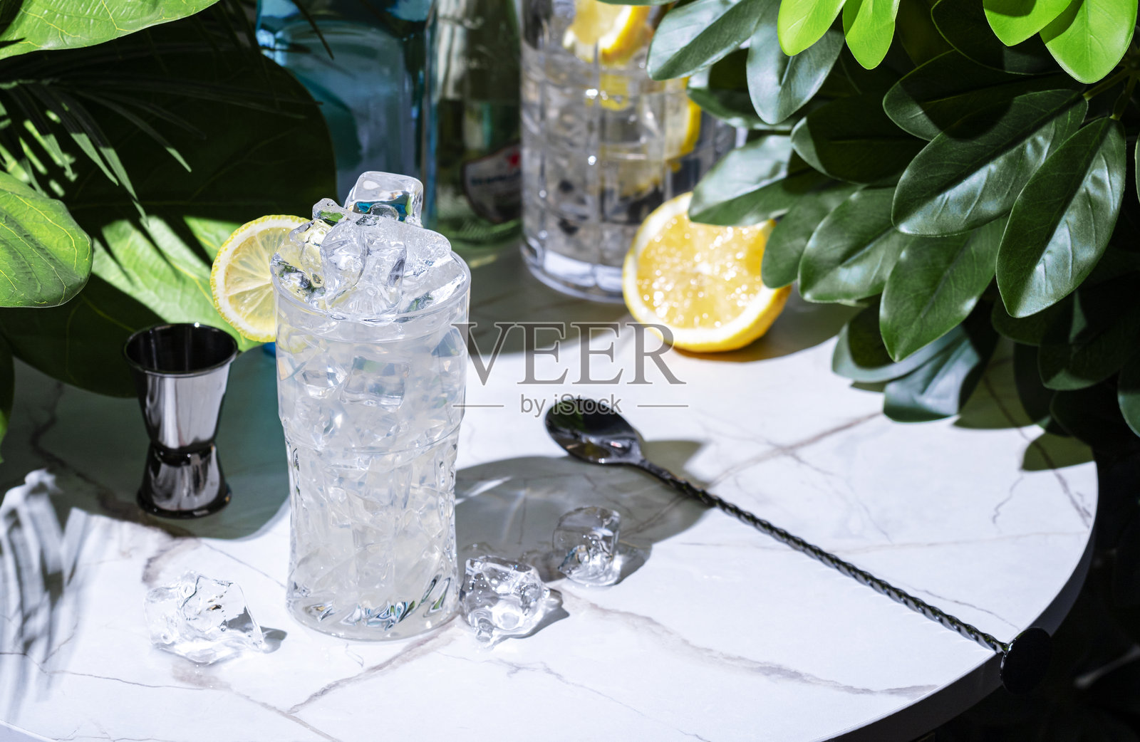 金汤力，含有杜松子糖浆、柠檬汁、汤力水和柠檬片的鸡尾酒，配有酒吧工具照片摄影图片