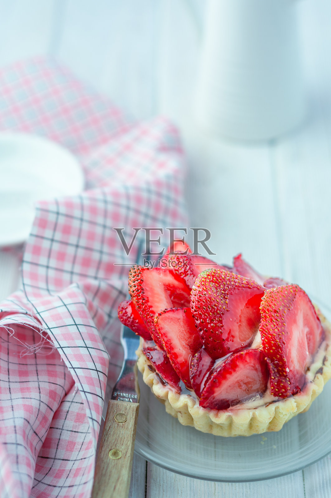 玻璃盘上的草莓挞与一把乡村风格的叉子照片摄影图片