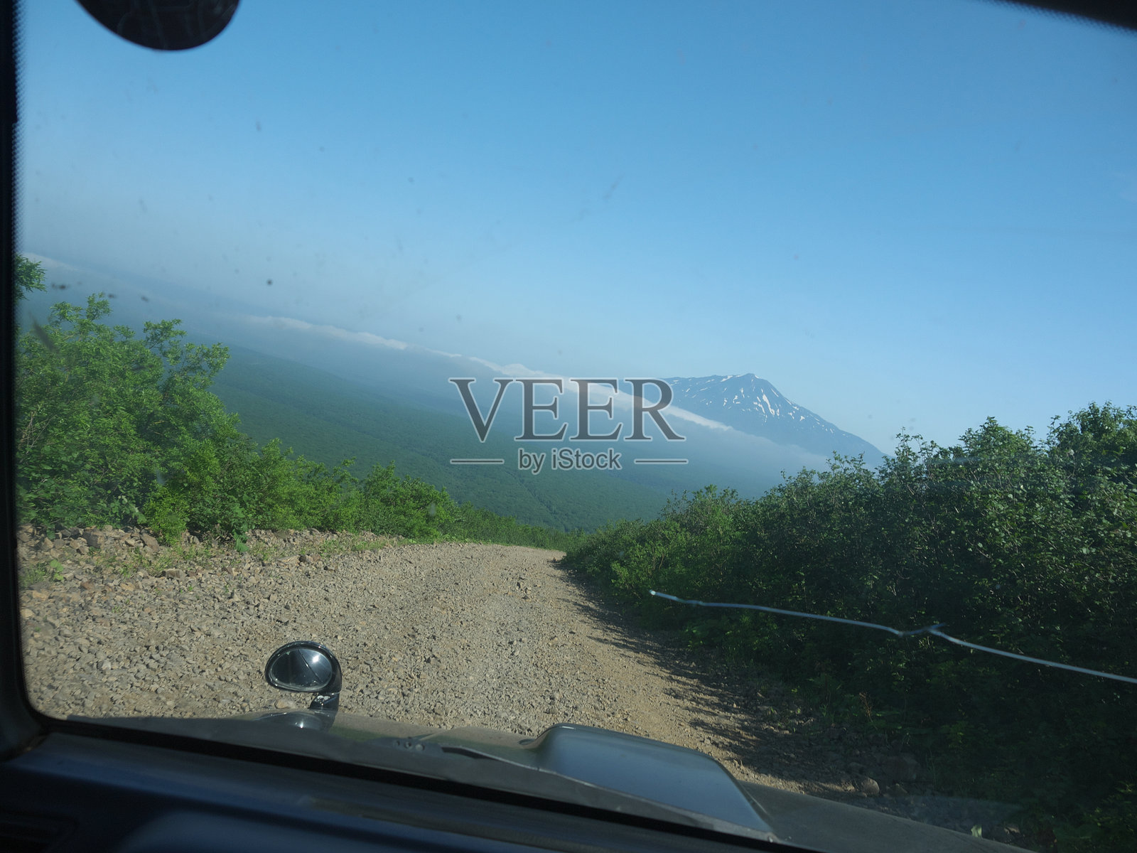 山间小道的越野旅行，火山峰顶在云层之上照片摄影图片