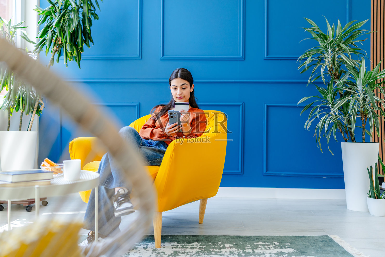 年轻女性在明亮的客厅里享受使用智能手机的时光照片摄影图片