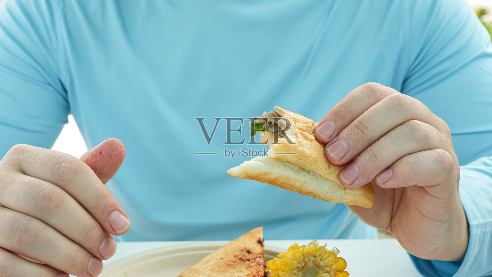 个人在桌子旁享用美味的三明治，配有新鲜的食材，色彩缤纷的盘子和生动的食物摆盘，突显了烹饪的乐趣。照片摄影图片