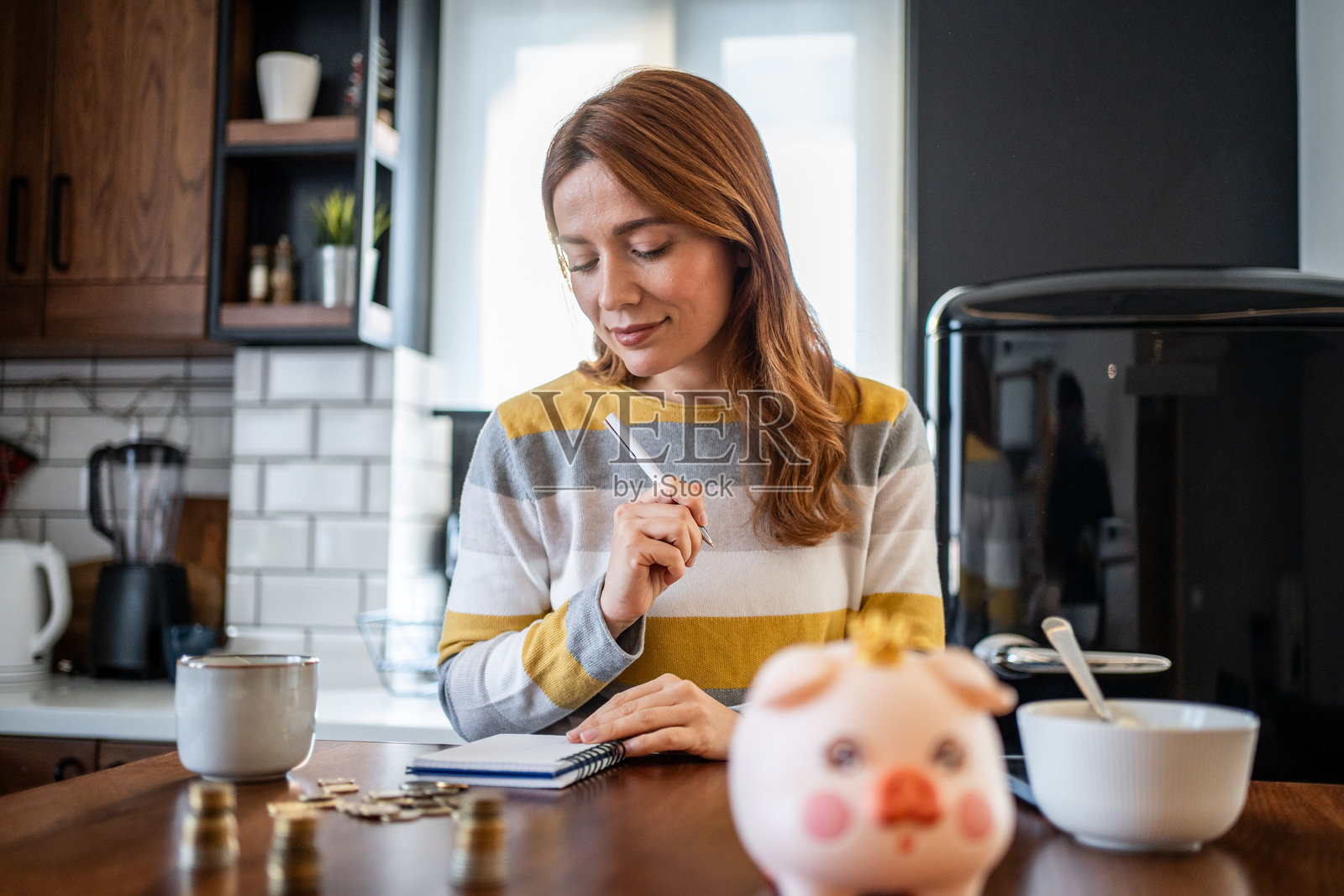 女性在厨房管理家庭财务和储蓄照片摄影图片