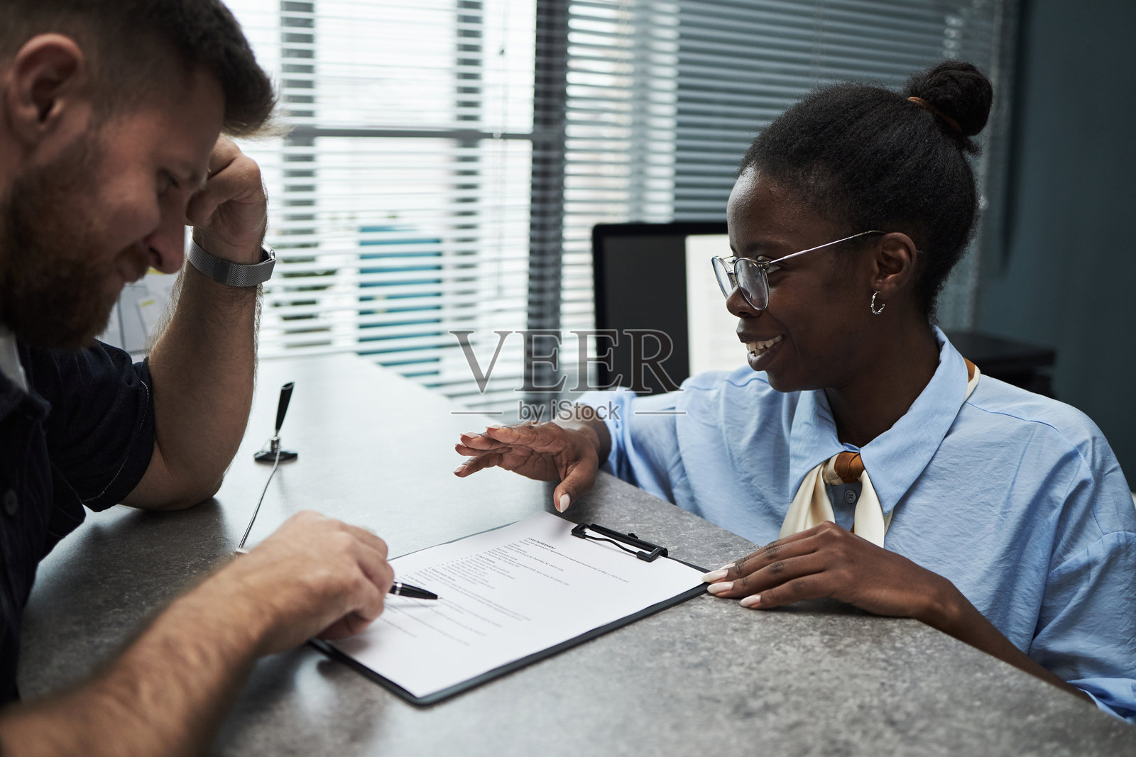 黑人女性助理在银行协助男性客户签署文件照片摄影图片