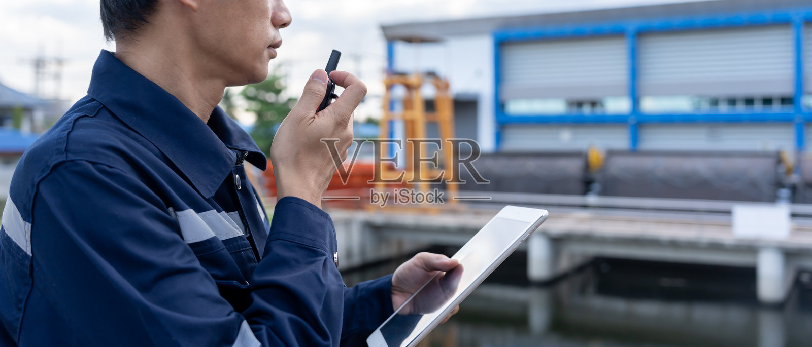 维护和检查员。维护工程师正在使用对讲机通知建筑和结构检查的结果。灌溉工程师正在探索闸门系统。照片摄影图片