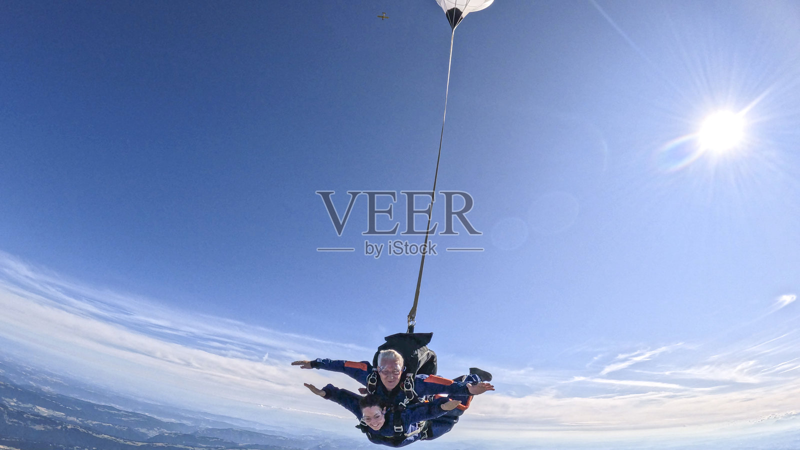 双人跳伞者一起在空中飞翔照片摄影图片
