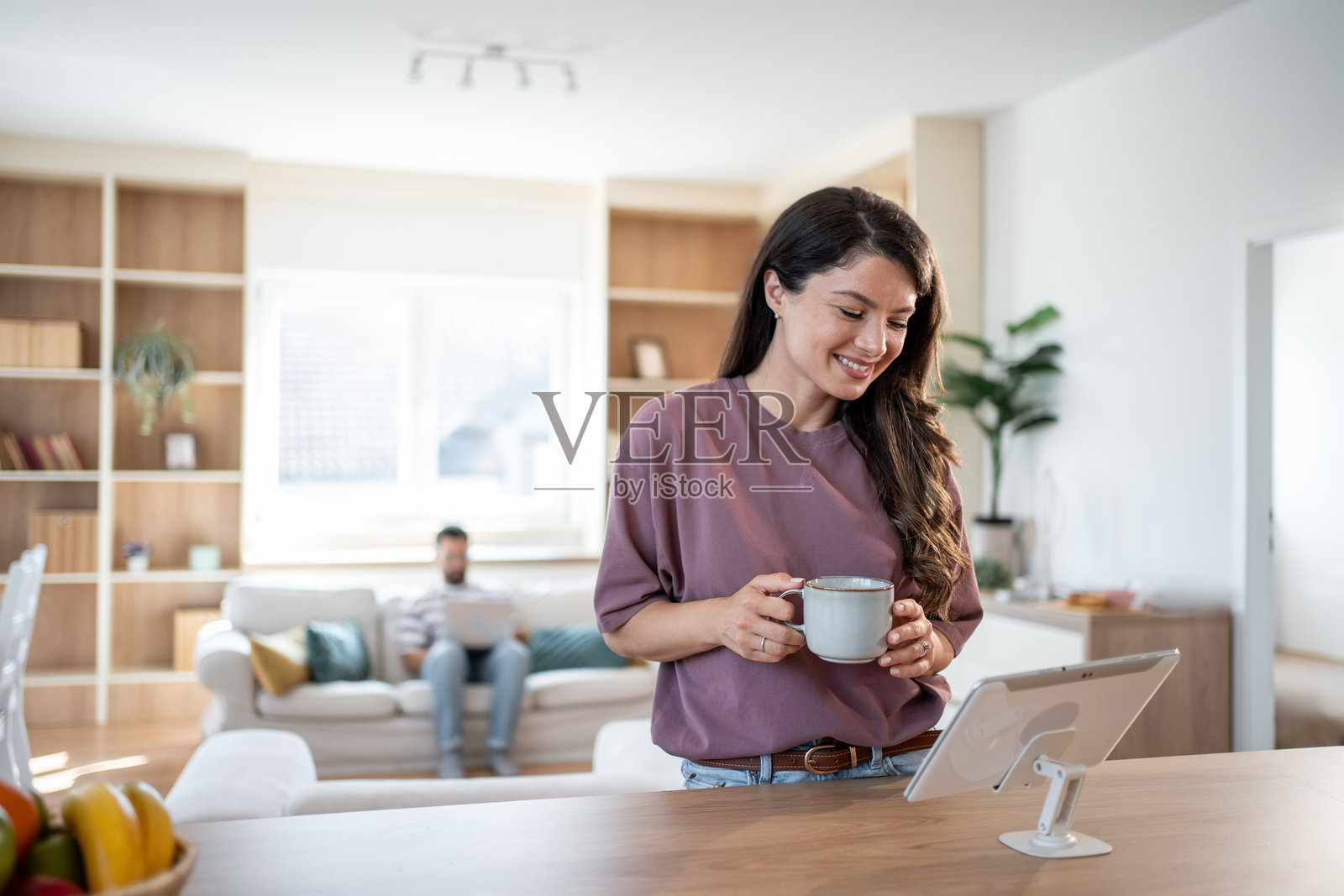 女人在家享受早晨咖啡并使用平板电脑照片摄影图片