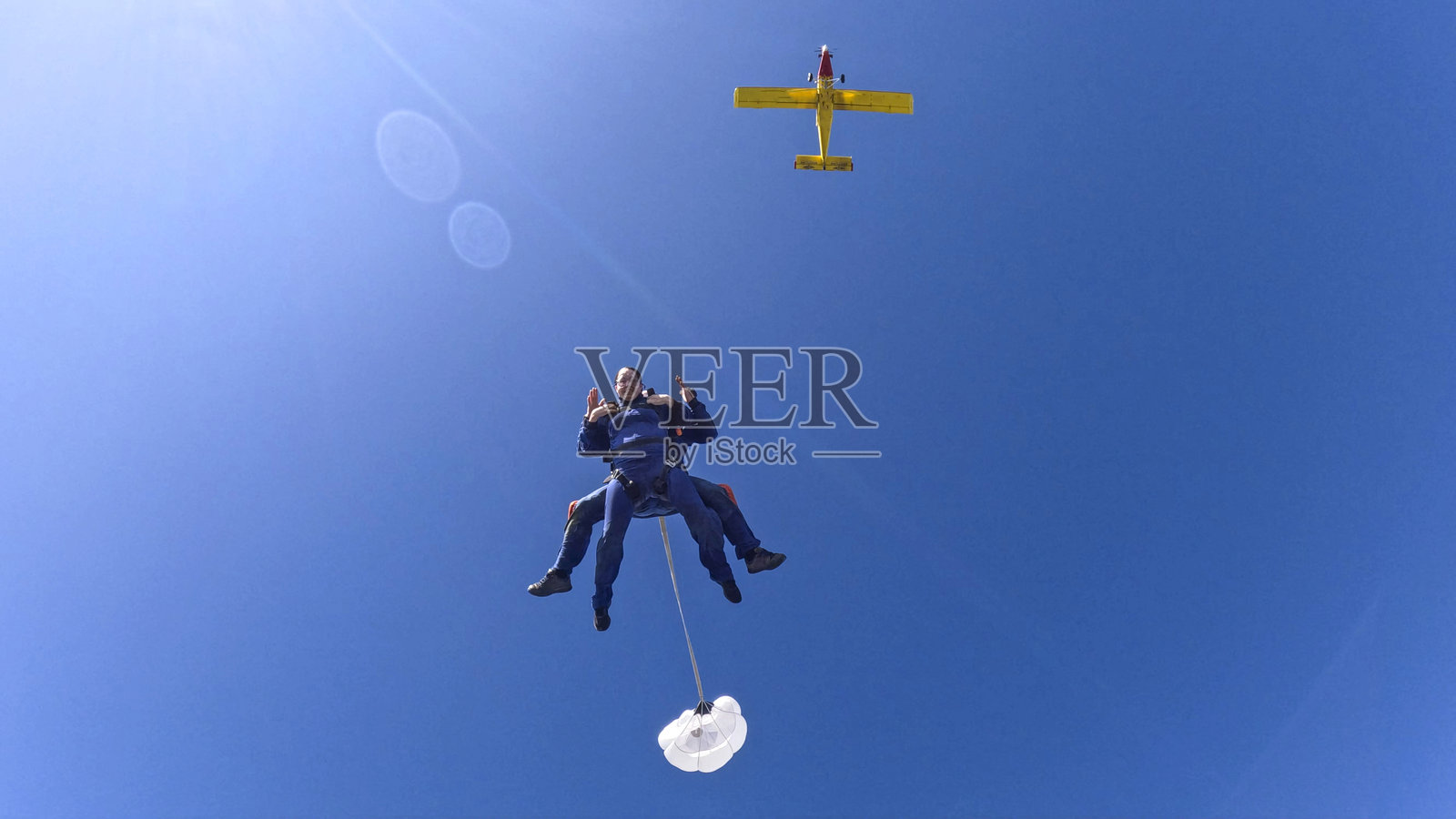 双人跳伞者一起从飞机上跳下照片摄影图片