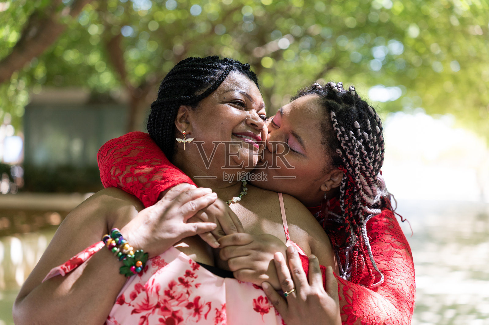 女儿在公园里亲吻并拥抱她的母亲照片摄影图片