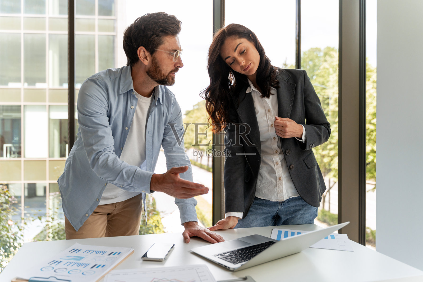 商务伙伴在办公室会议上讨论笔记本电脑。照片摄影图片