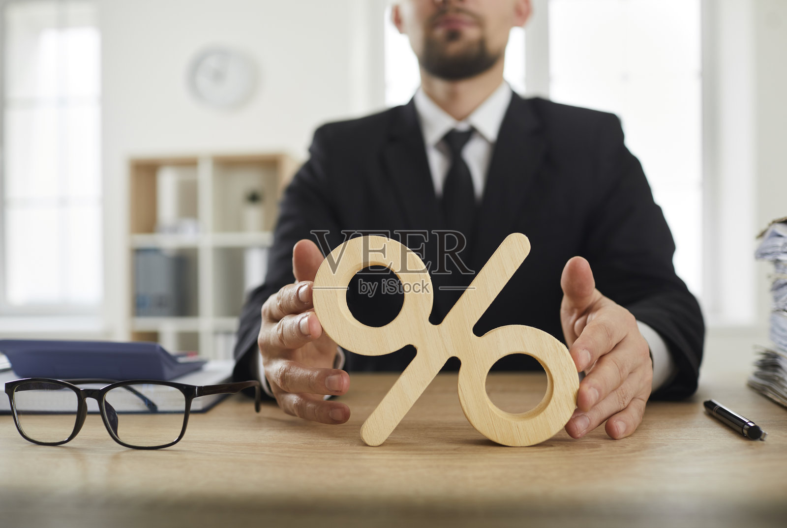 商业人士办公桌上的百分号特写，象征着利率。照片摄影图片