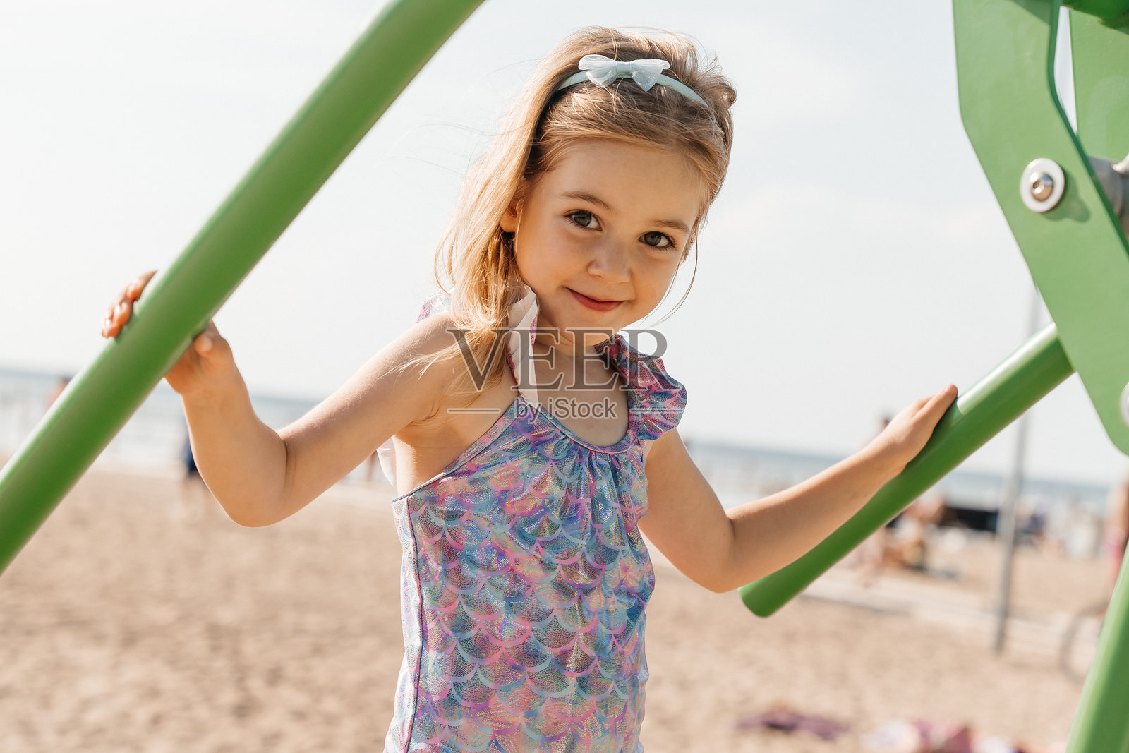 小女孩在阳光明媚的海滩日子里享受游乐设施的乐趣照片摄影图片