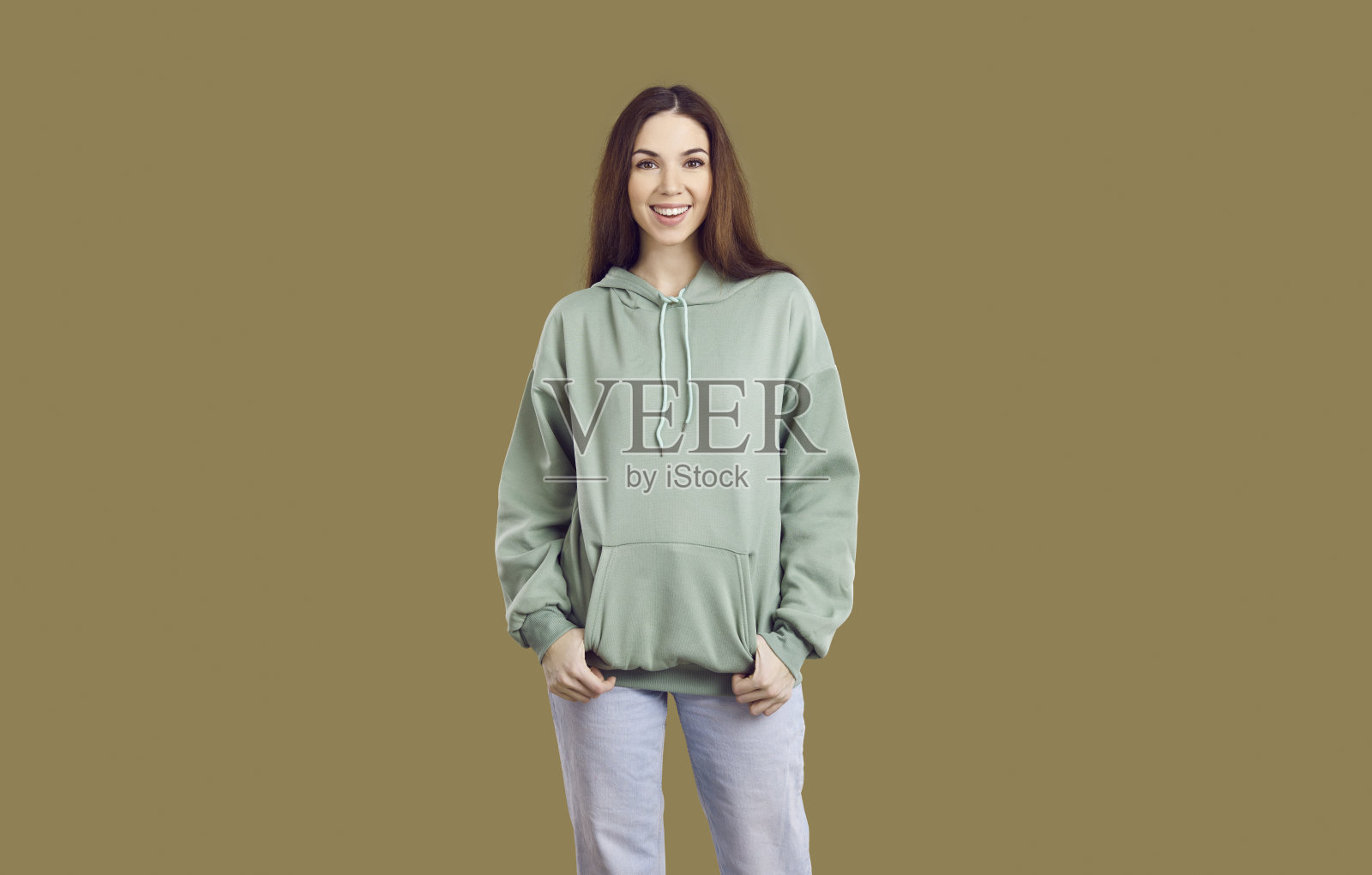 微笑的美丽年轻女性或少女穿着舒适的连帽衫和牛仔裤的肖像照片摄影图片