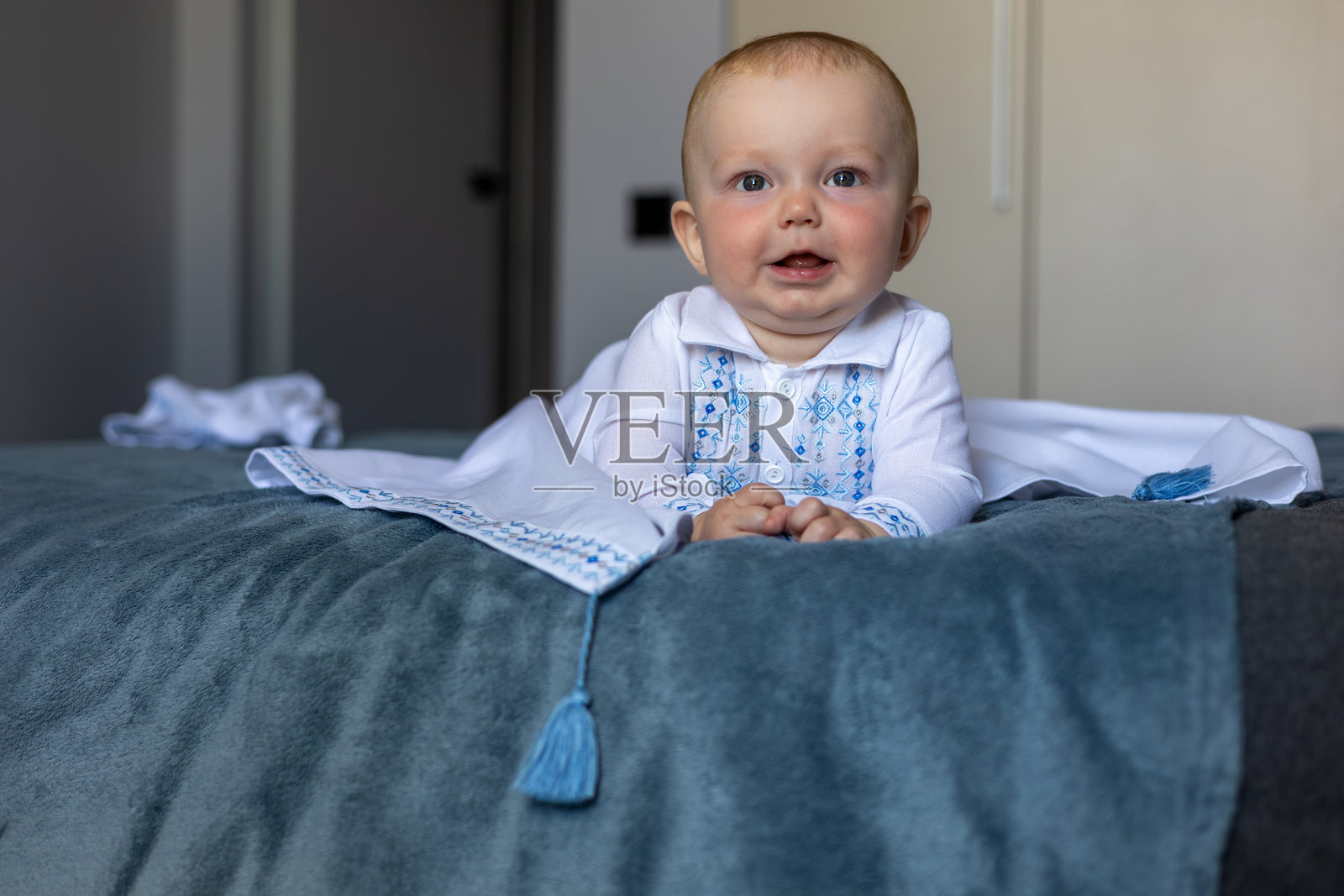 穿着刺绣白色服装的婴儿与母亲在家中照片摄影图片