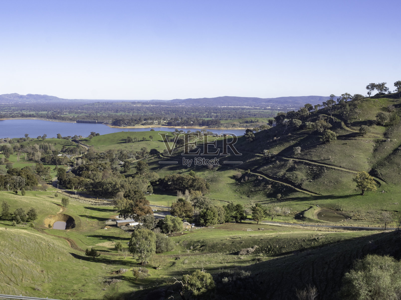 高角度俯瞰湖边的起伏丘陵和农田照片摄影图片