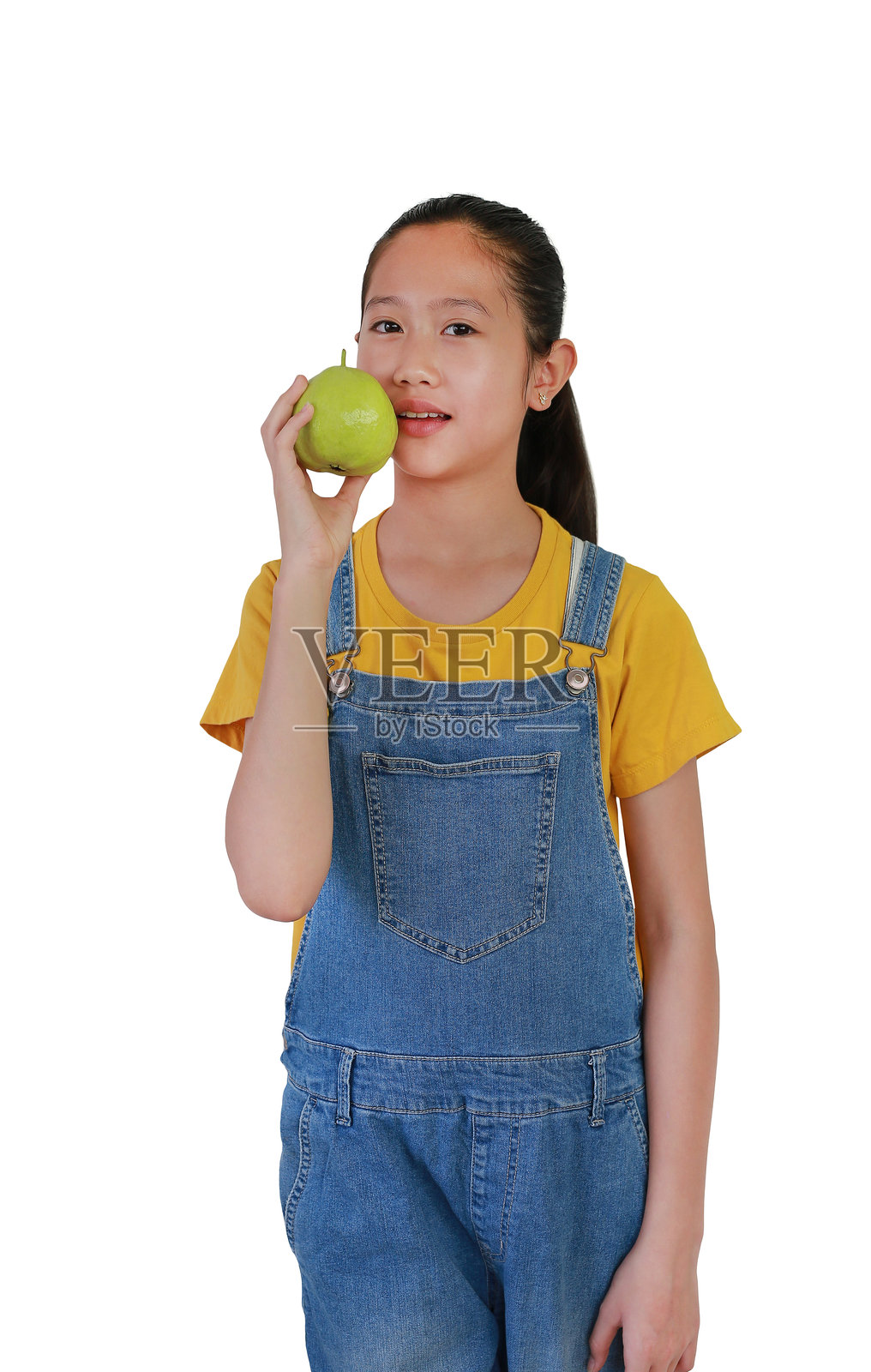 亚洲女孩手持新鲜番石榴，面向镜头，背景为白色摄影棚。照片摄影图片