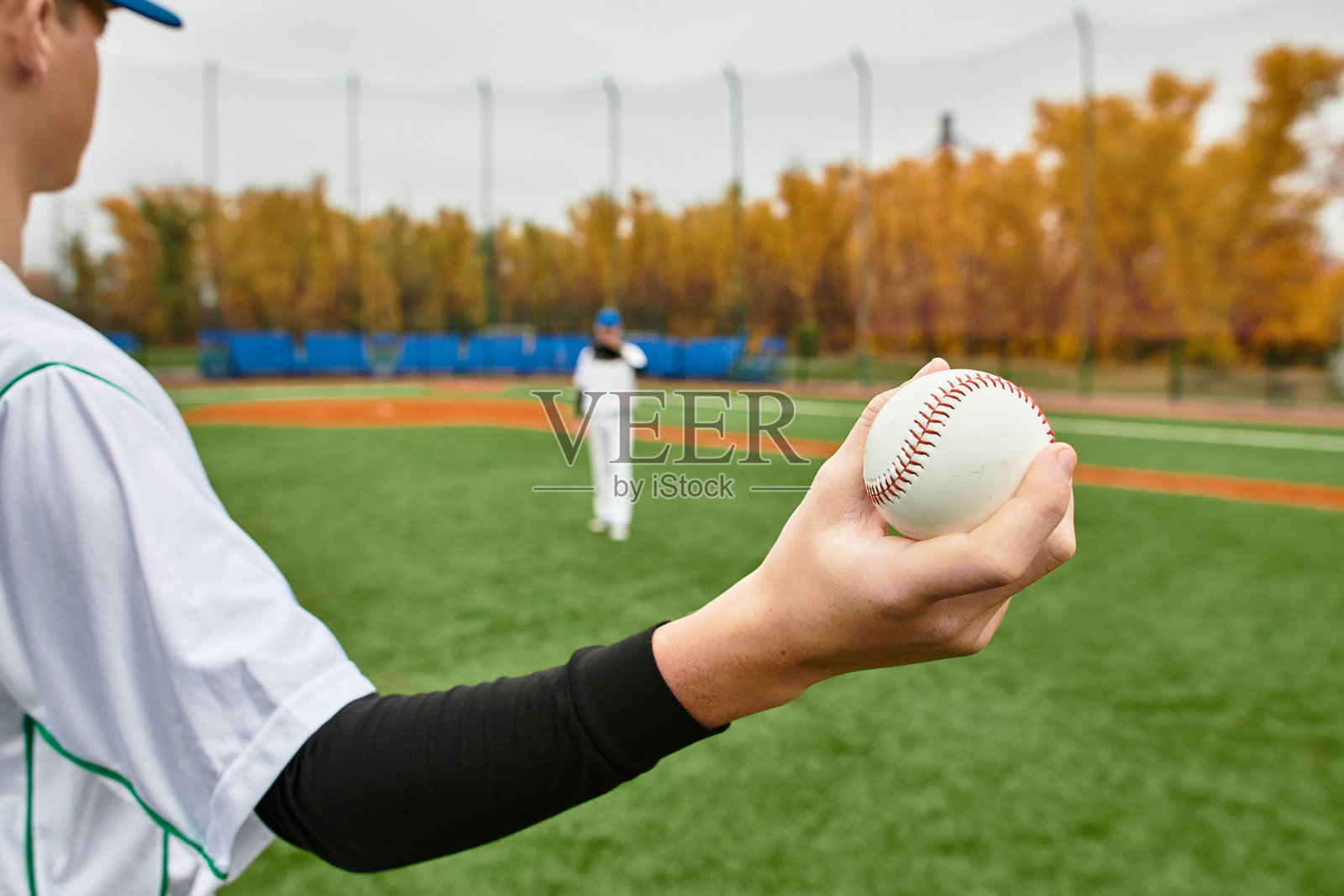 两个青少年男孩在秋天的生机勃勃的球场上热情地练习棒球照片摄影图片