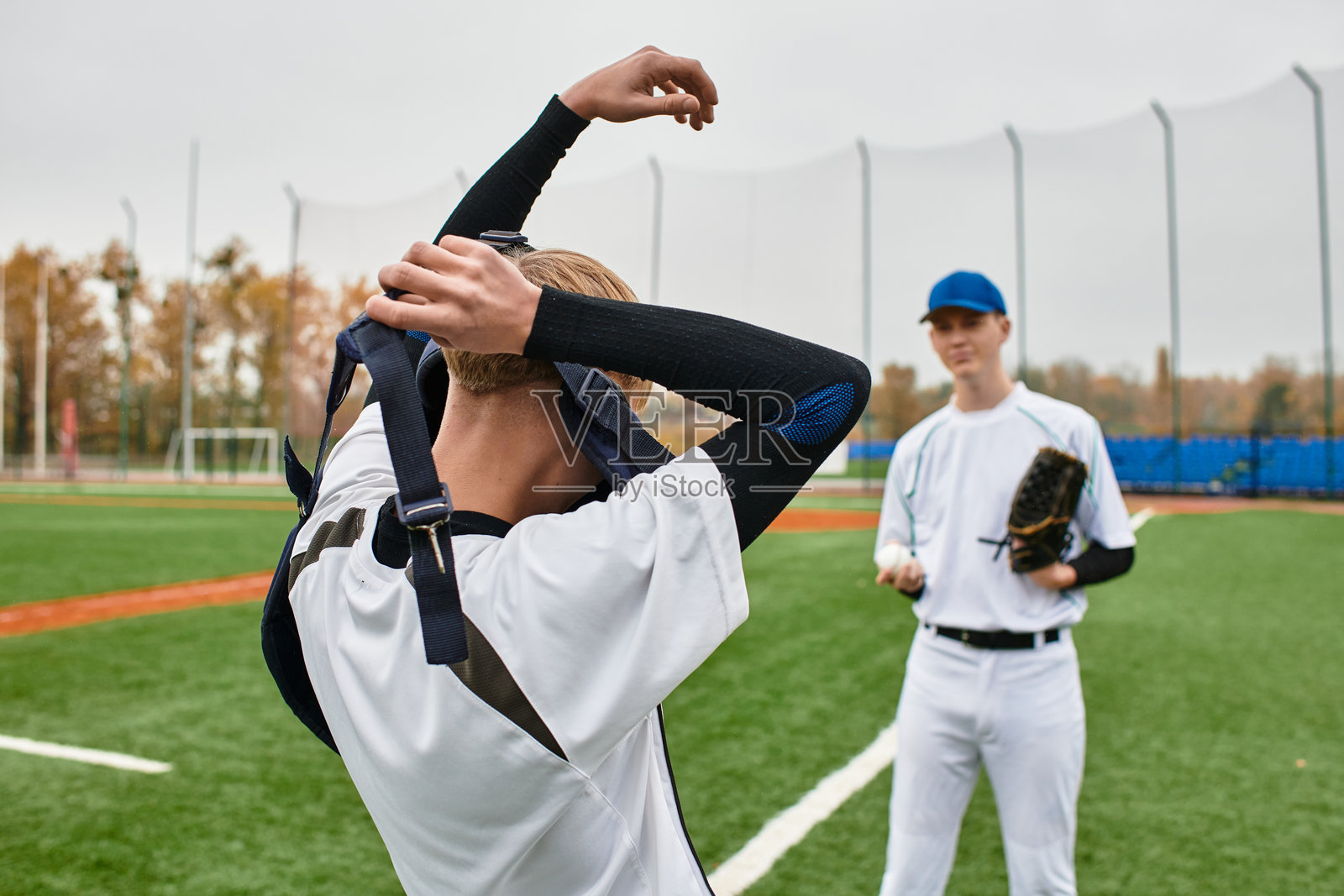 青少年男孩在秋天的生机勃勃的绿茵场上享受棒球训练照片摄影图片