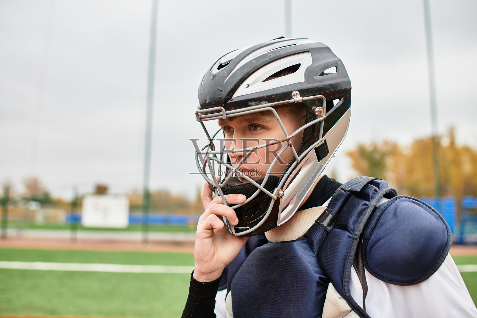 一名年轻运动员在棒球场练习时专注于下一步动作。照片摄影图片
