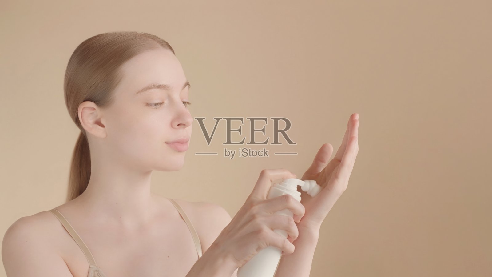 女性在手上涂抹护肤泡沫，进行自我护理。留白空间。照片摄影图片