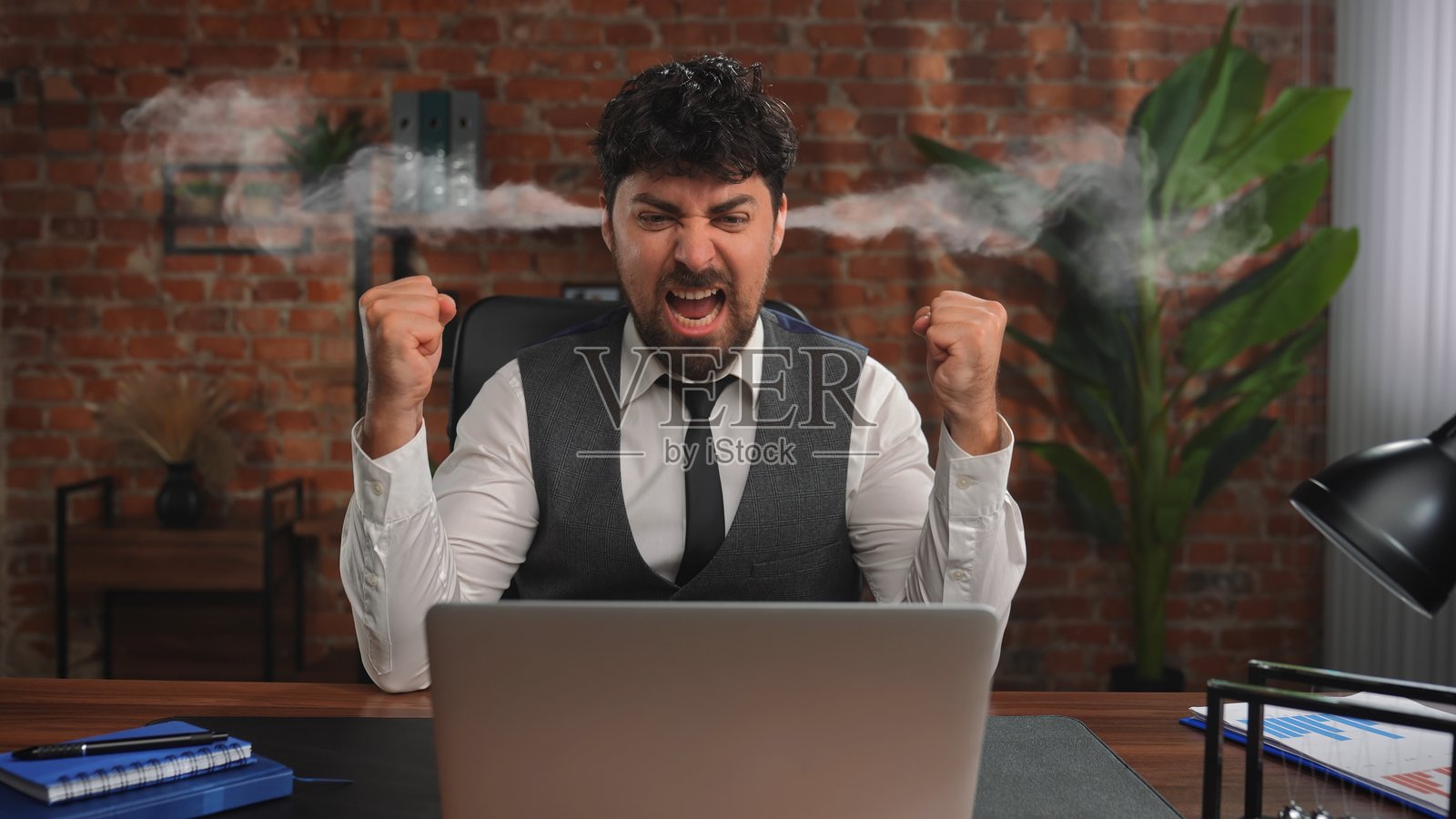 商人在阁楼风格的办公室工作，因过度劳累而感到压力。照片摄影图片