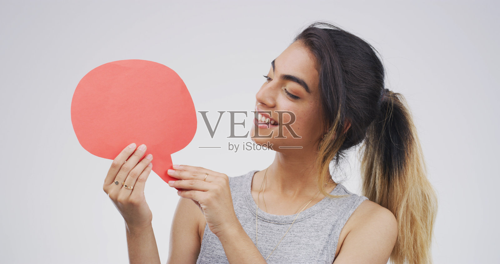 演讲气泡、展示空间和工作室中的女性，用于社交媒体的公告、意见或声音。快乐的女性与文本板、空白标志或海报在白色背景下投票。照片摄影图片