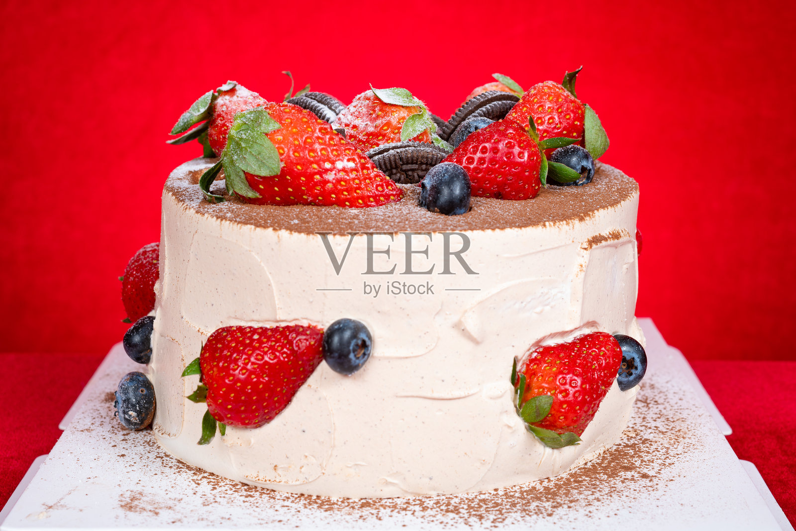 角度视图的生日蛋糕，上面装饰着水果和饼干，呈水平构图。照片摄影图片