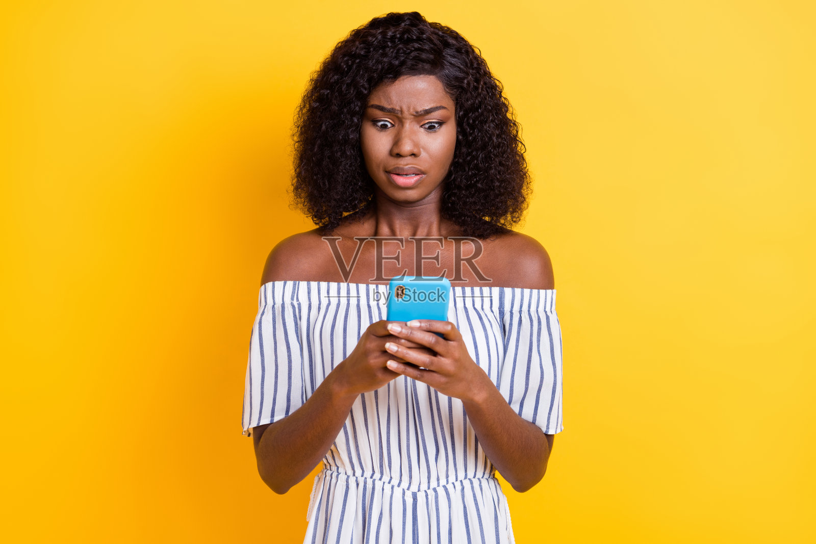 吸引人的忧虑专注女孩使用电子设备浏览假新闻媒体，背景为明亮的黄色。照片摄影图片