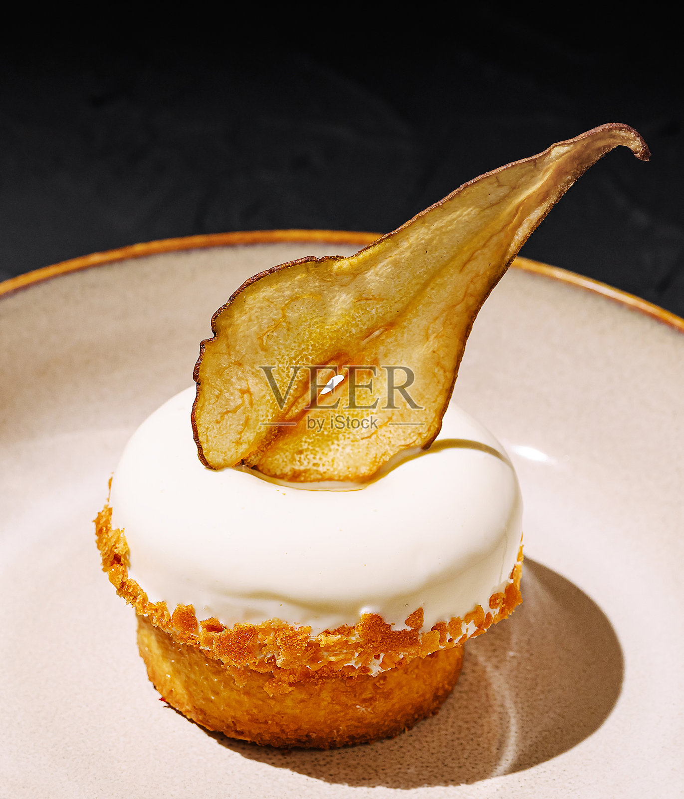 美味的甜点，顶部有奶油和干果，放在深色表面上照片摄影图片