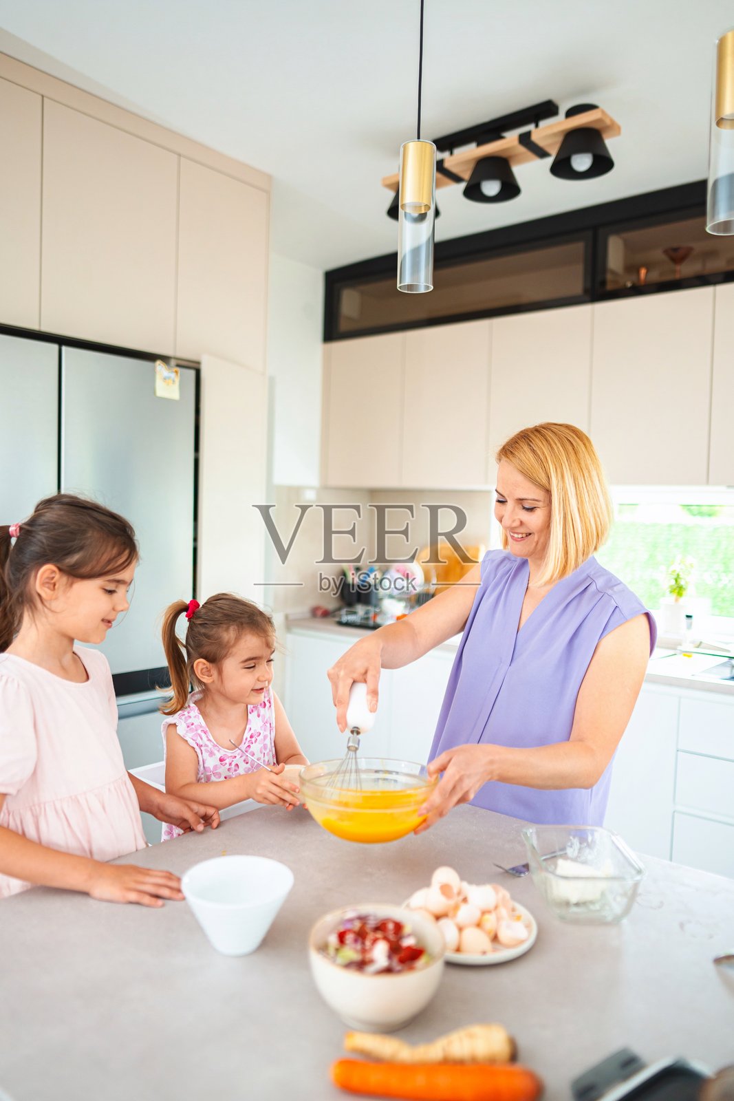 母亲和女儿们在现代厨房里准备食物照片摄影图片