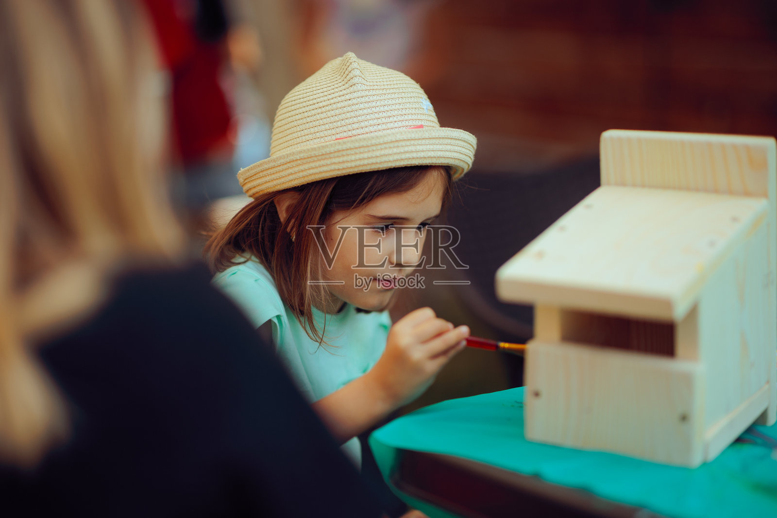 专注于她的DIY鸟屋项目的才华女孩照片摄影图片