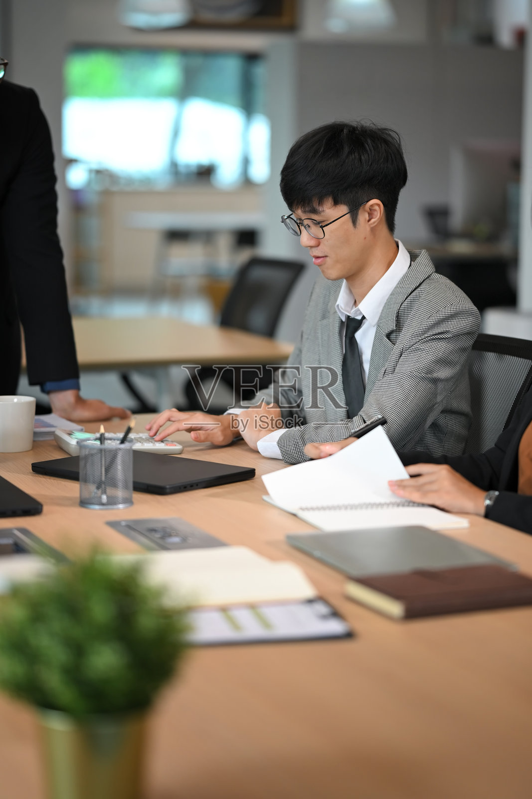 专注的商人在协作工作空间中审查数据并进行计算照片摄影图片