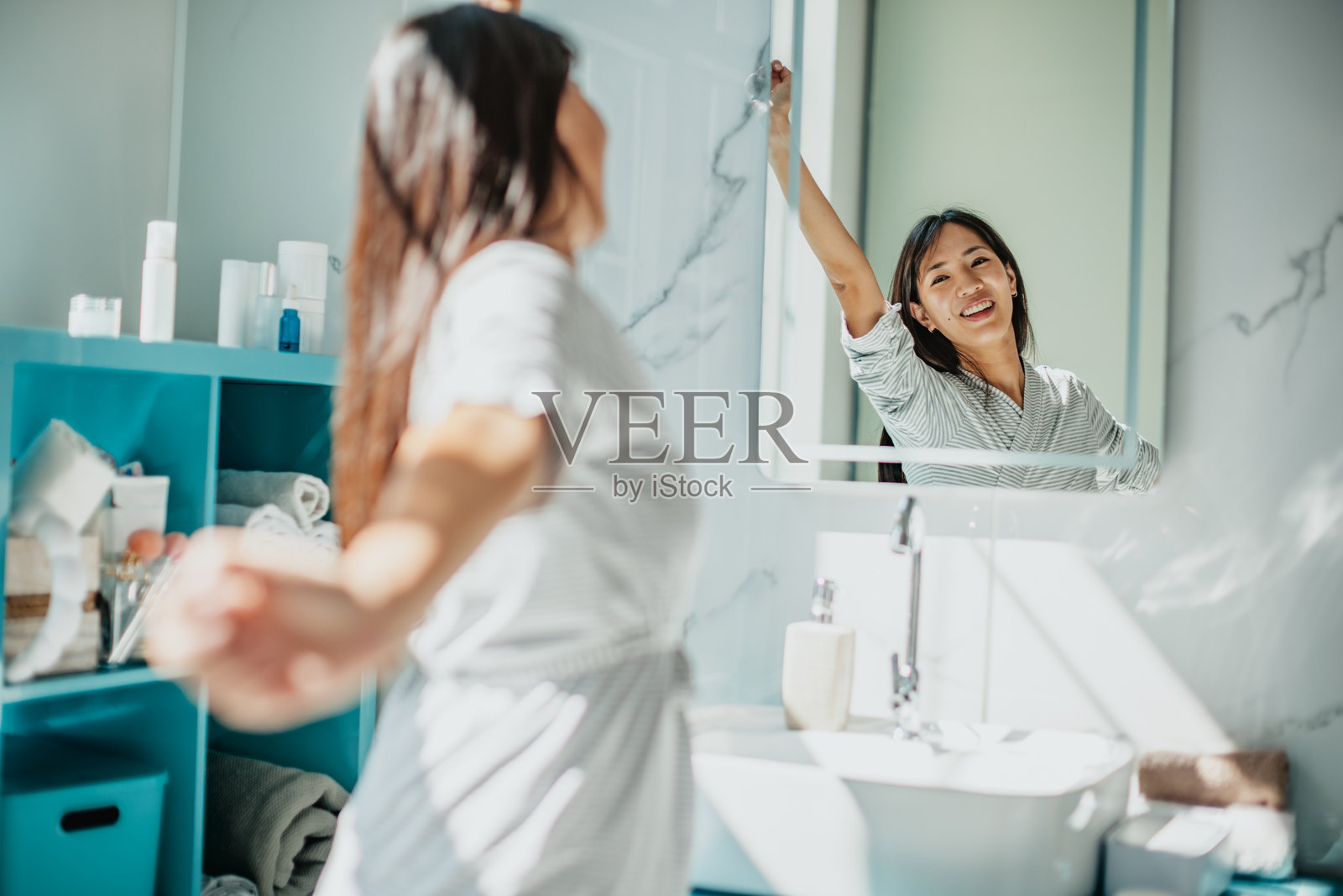 亚洲女性在明亮浴室环境中的早晨护肤程序照片摄影图片